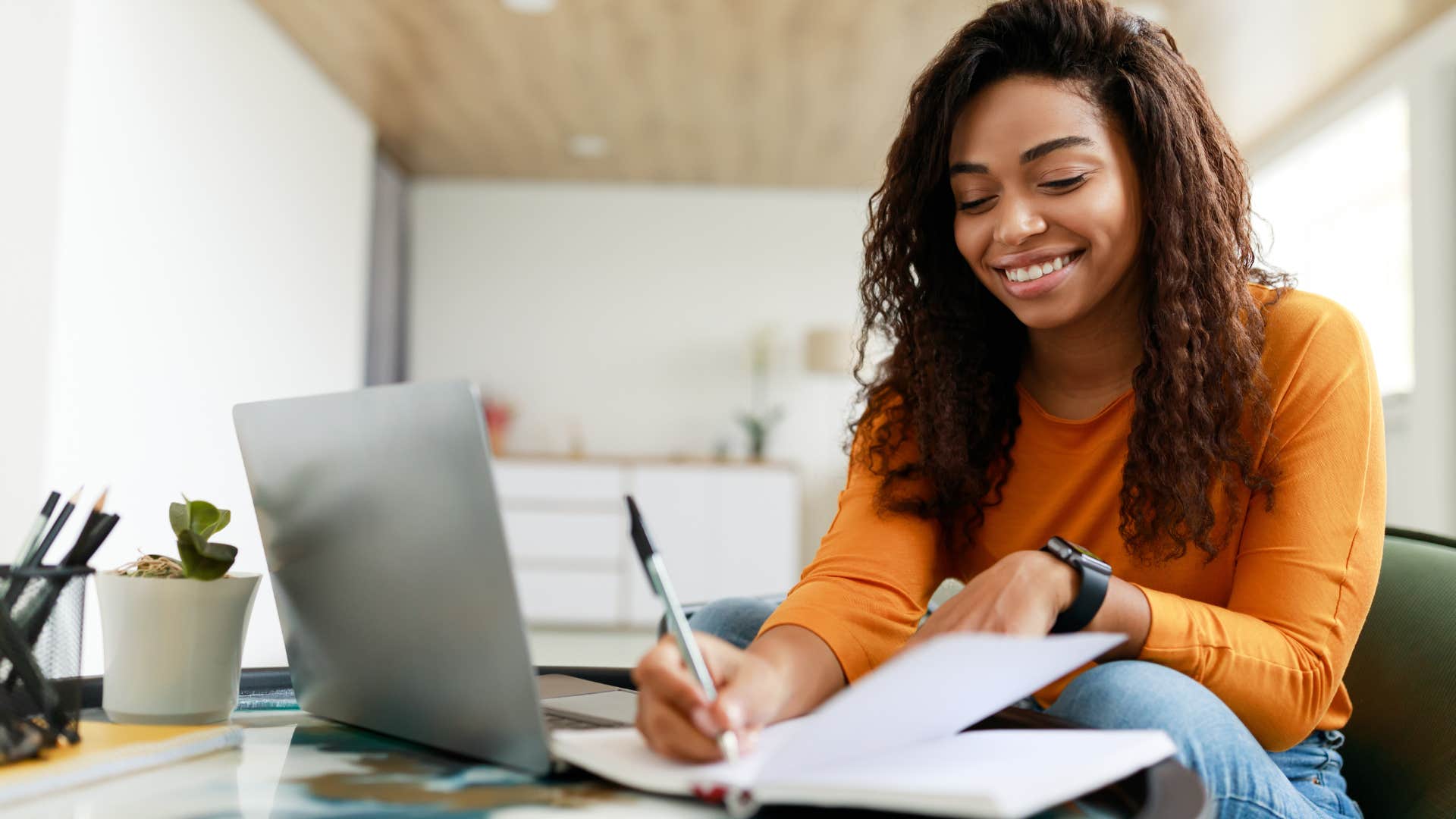 happy woman writing down her small financial wins