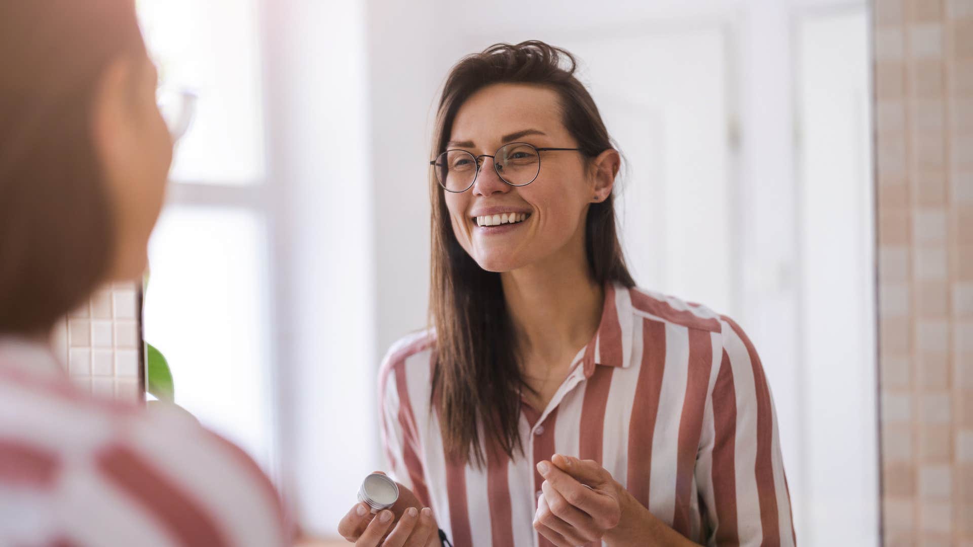 woman saying money affirmations in the mirror