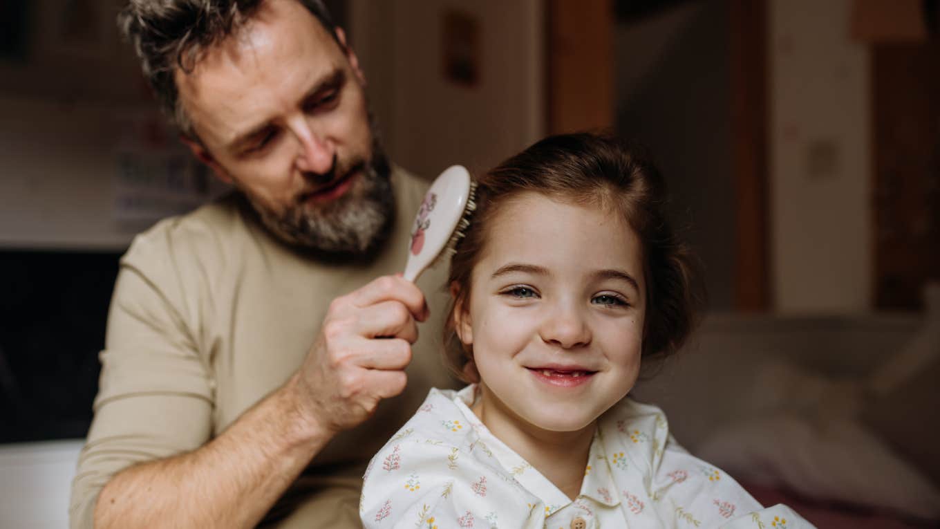 single dad brushing his daughter's hair