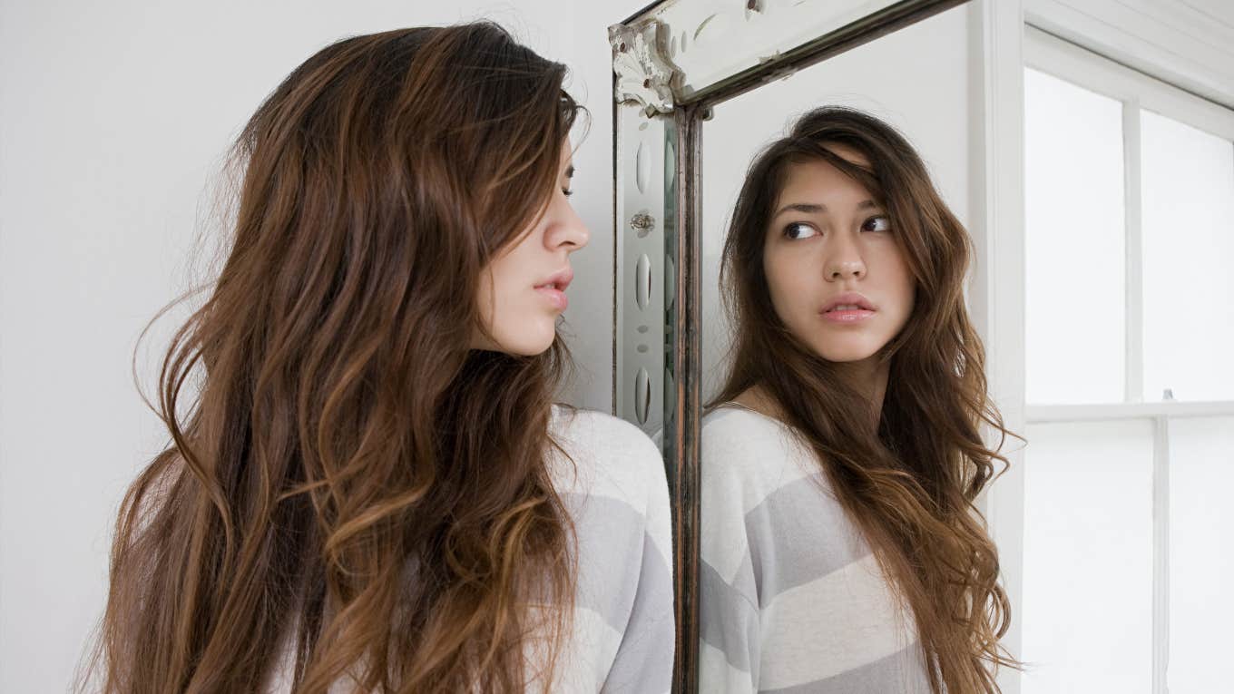 six behaviors that show someone has a fragile ego insecure woman looking in mirror