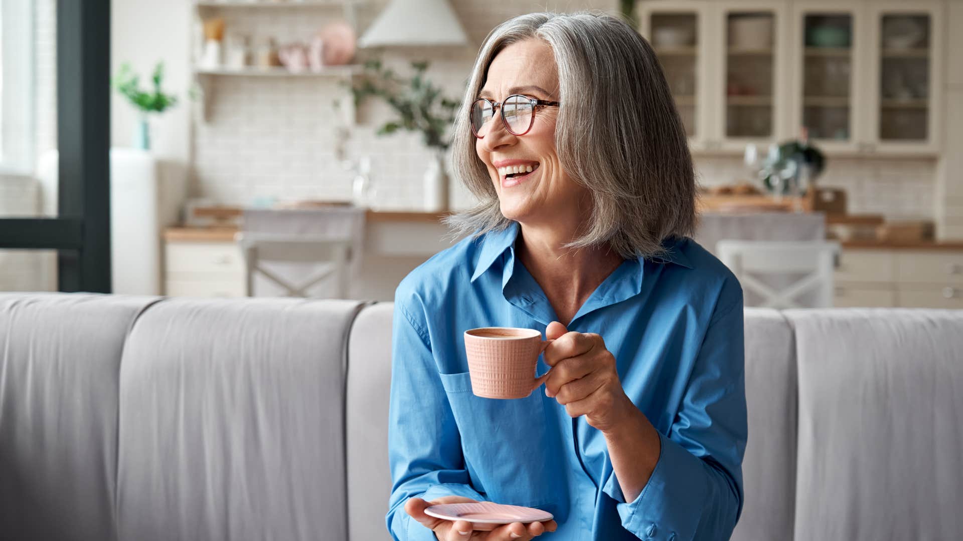 woman in blue shirt sipping tea for kicks as she smiles