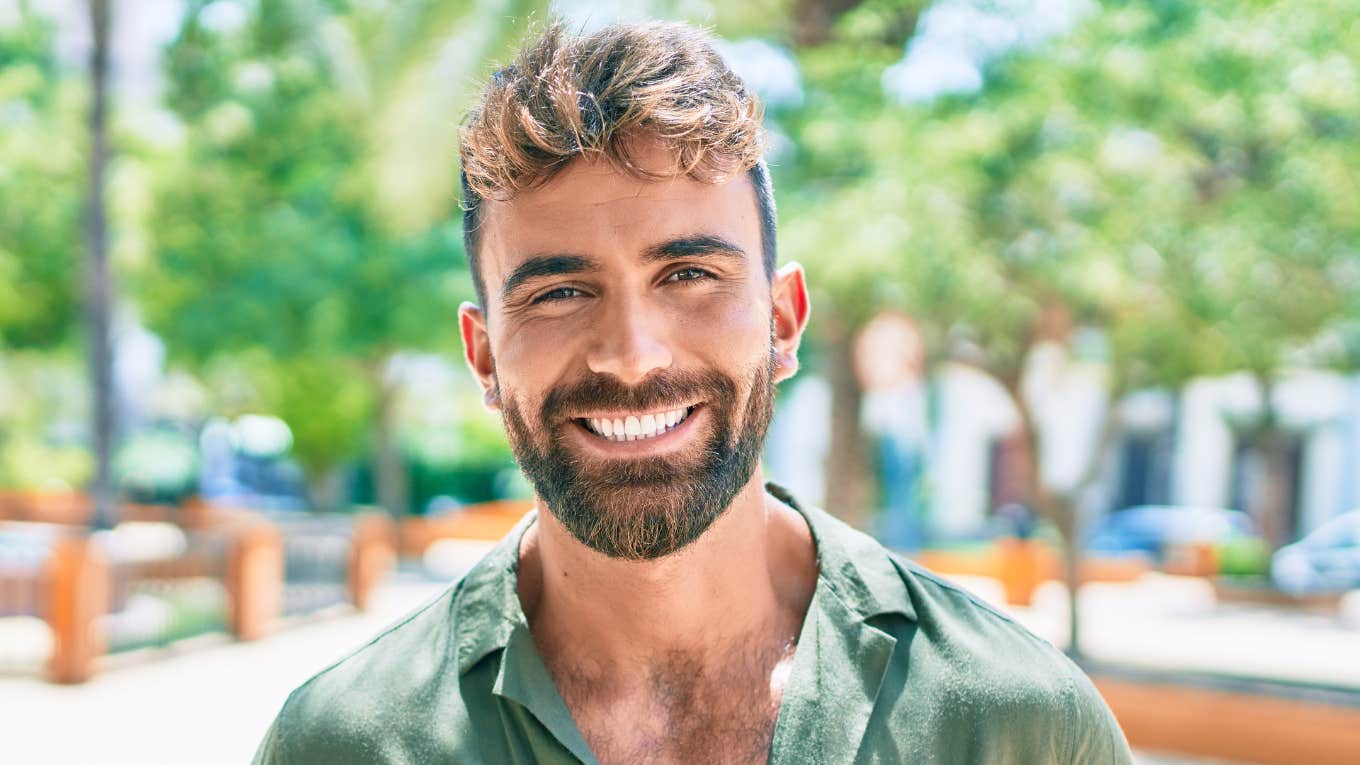 good man smiling standing outside