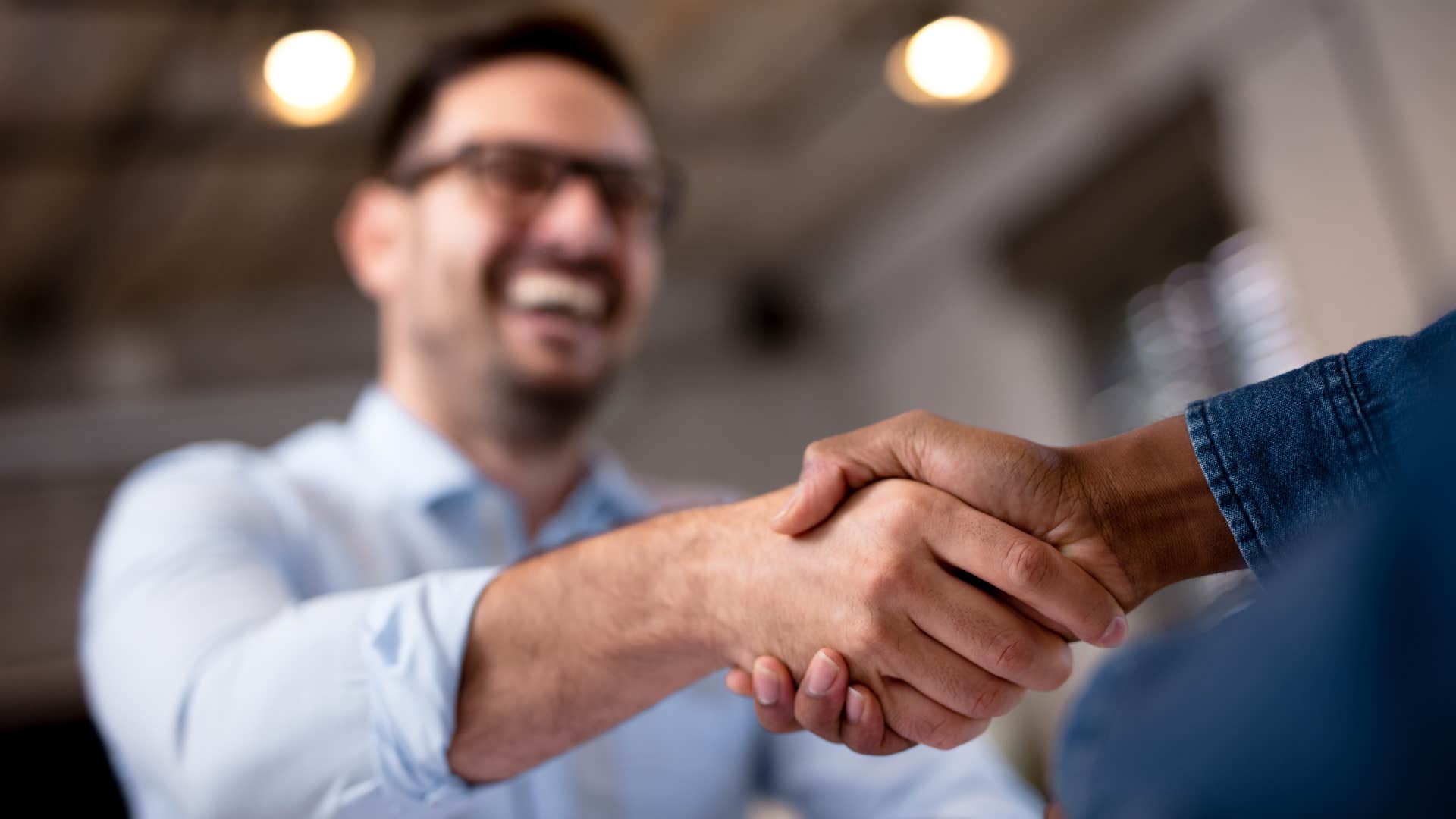 man shaking hands firmly with boss
