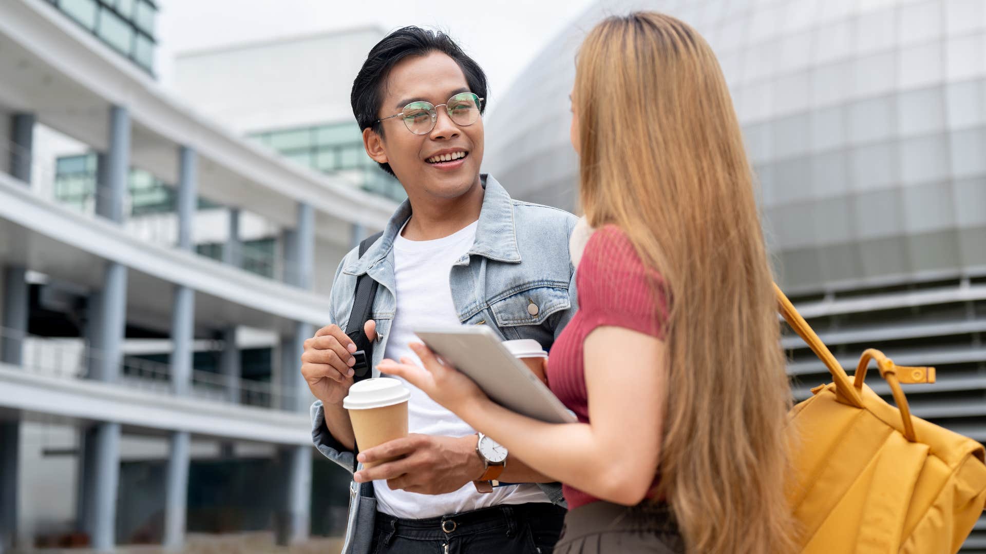 man listening more than he speaks as woman in pink shirt and books talks