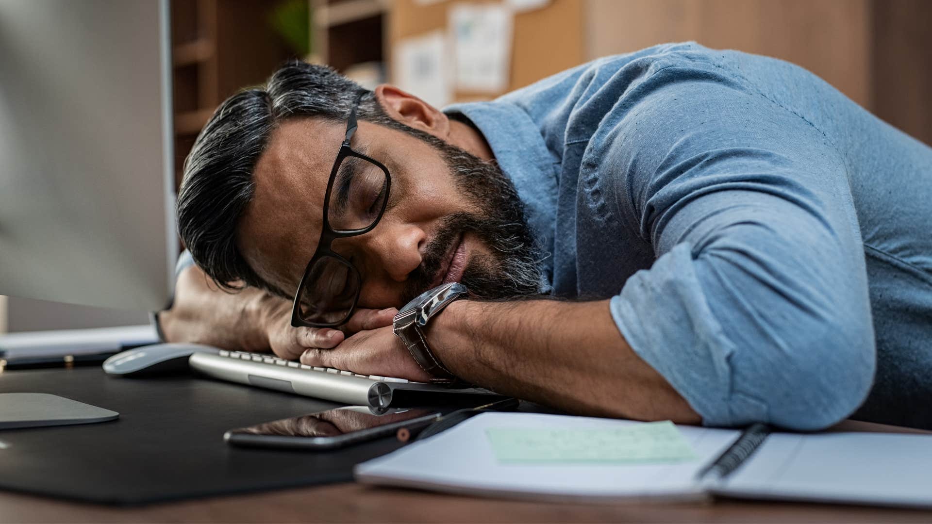 man in blue shirt and glasses neglecting his responsibilities 