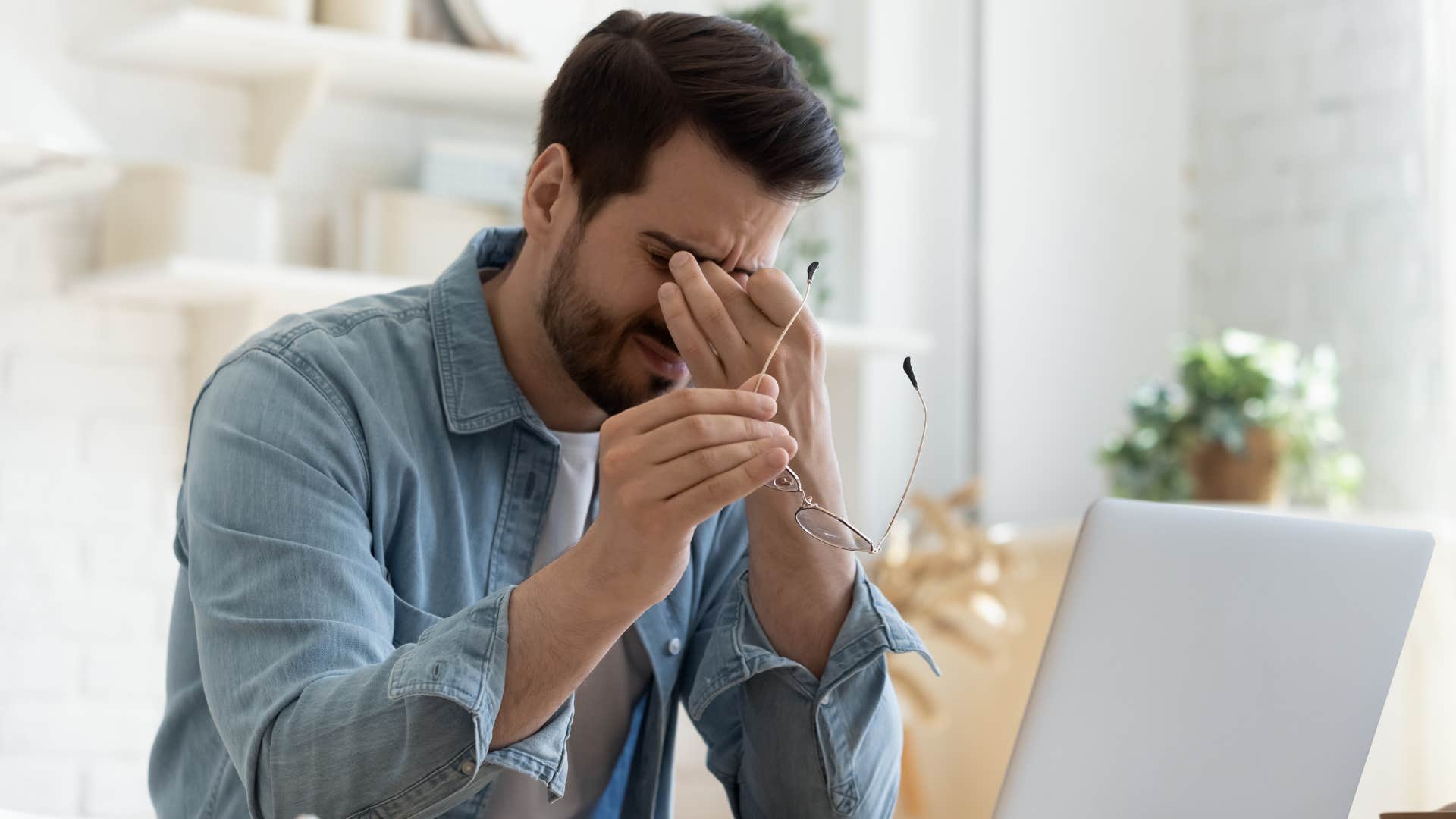 man rubbing eyes as he has a sudden mood swing