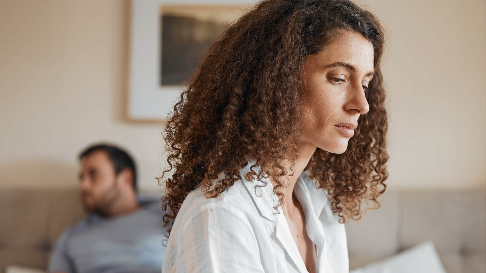 Woman turned away from her husband who withholds affection.