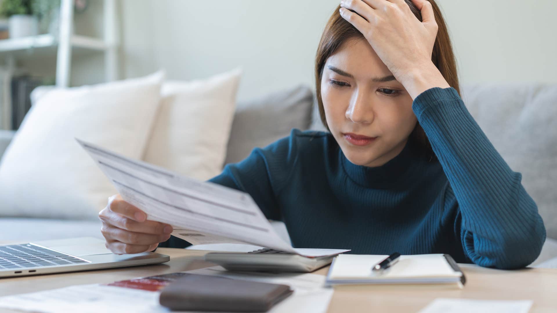 worried woman looking at paycheck