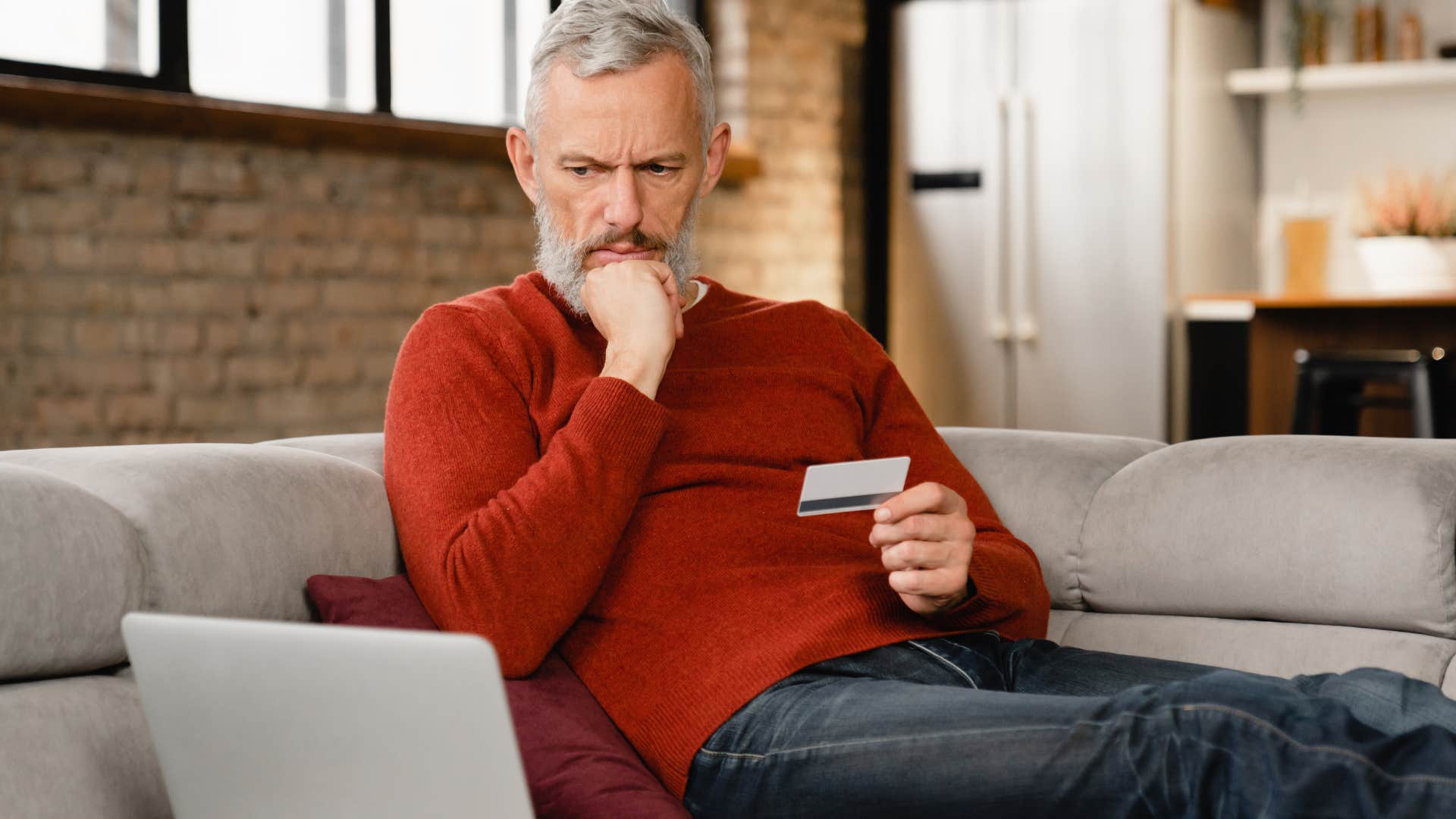 older boomer man who believes credit cards are bad doing bills