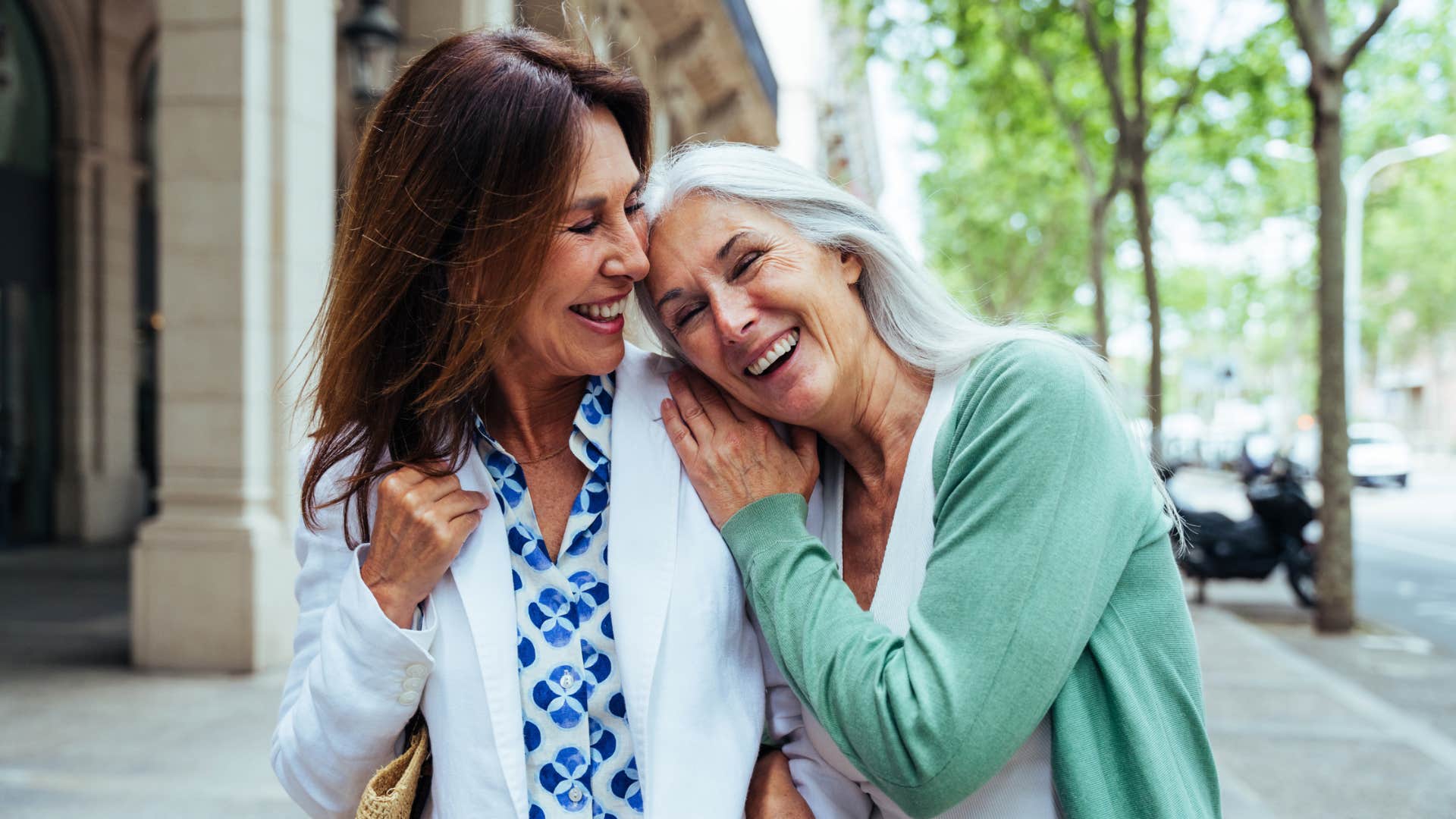 older female friends hugging on the street