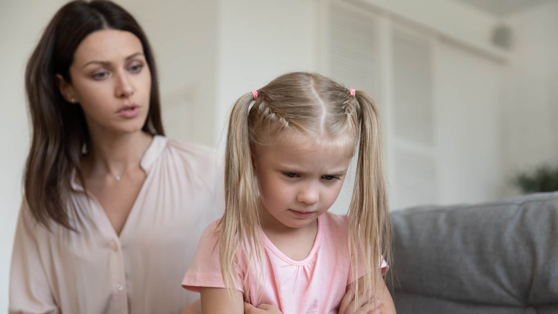 a little girl is upset that her busy mother will not play with her