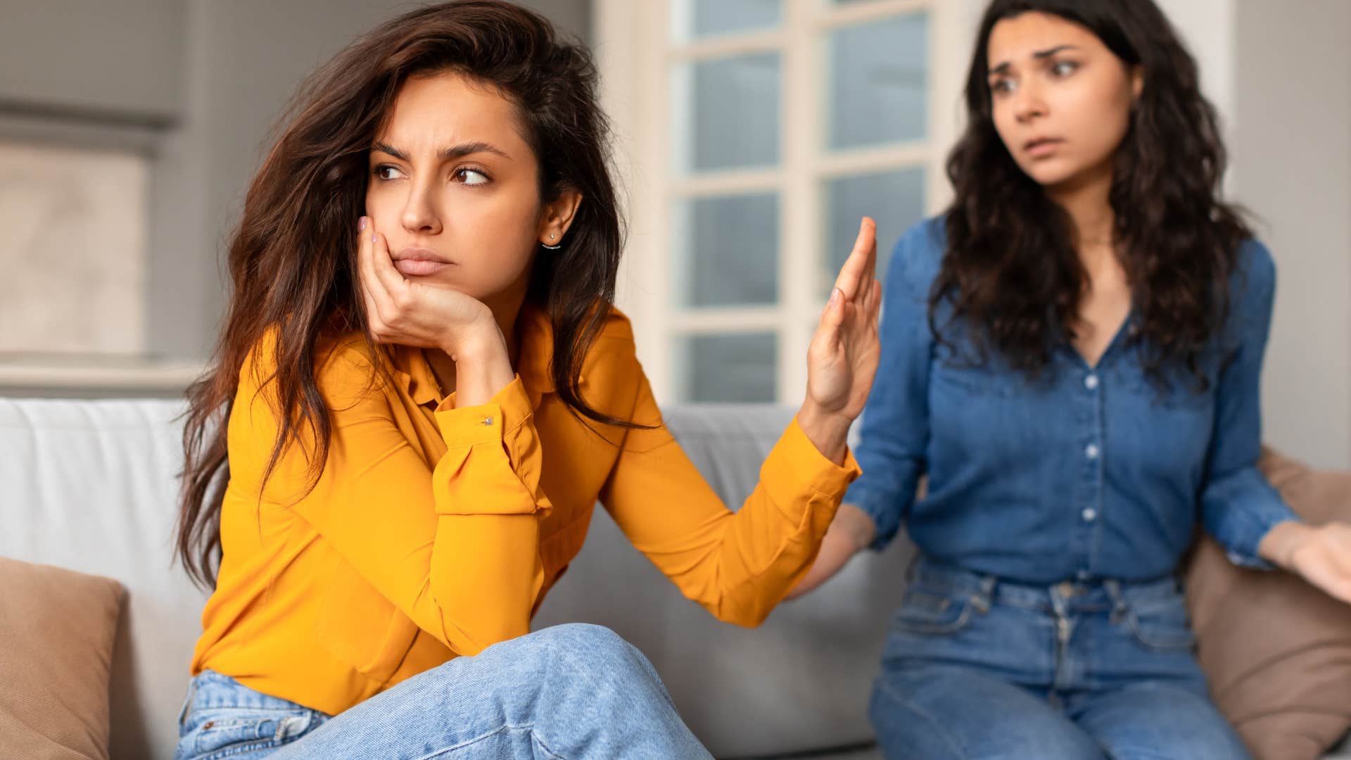 Woman who's not apologizing turned away from her friend.