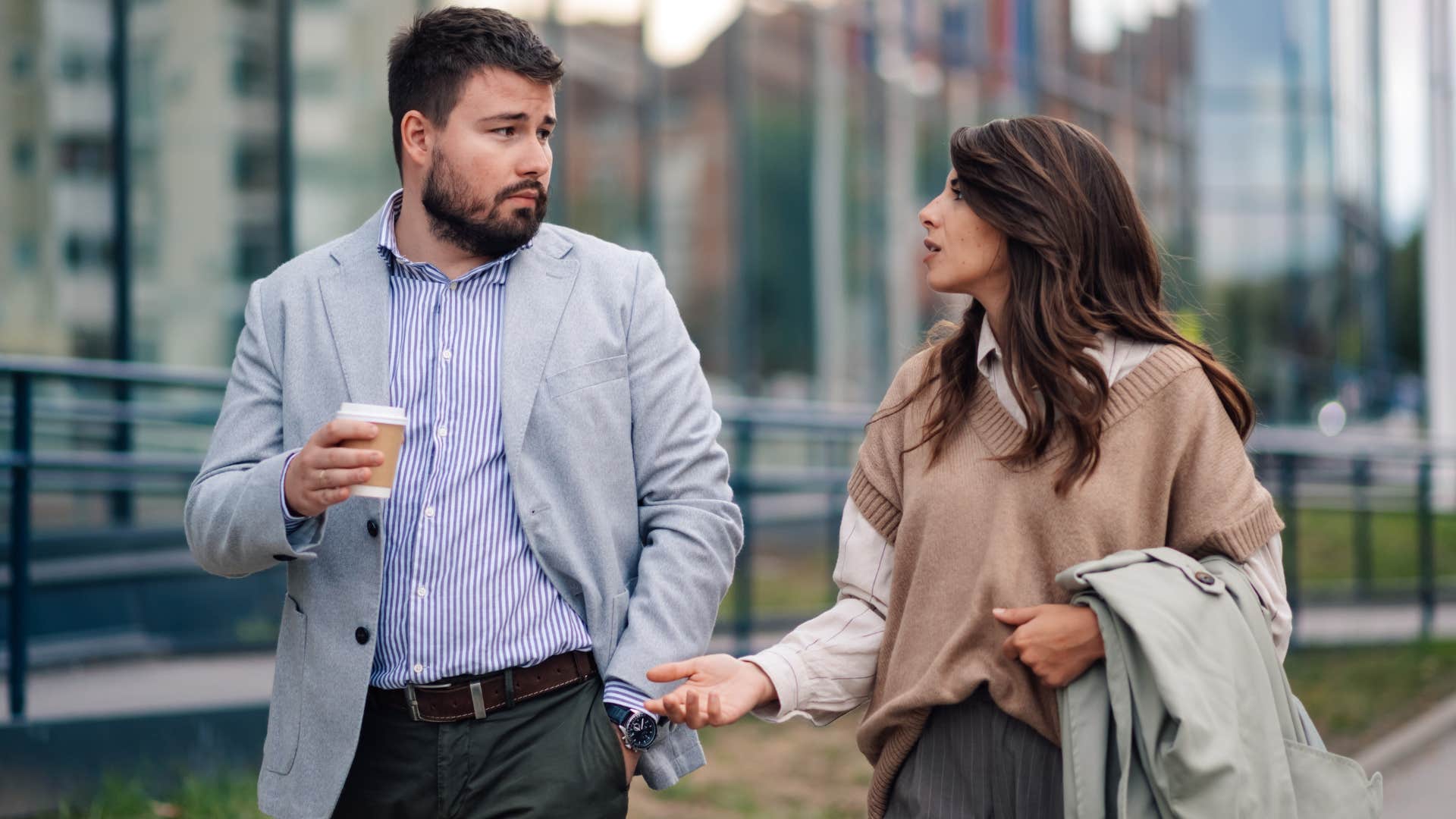 Woman saying "excuse me" to an upset man on the sidewalk.