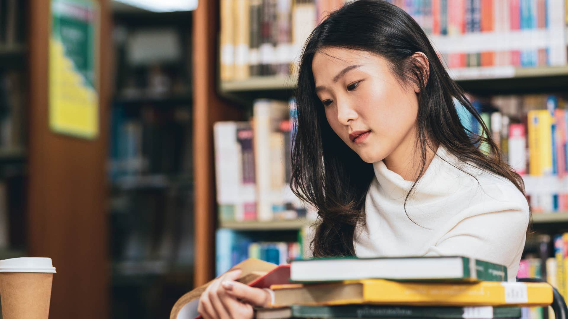 Woman reading books in a library.