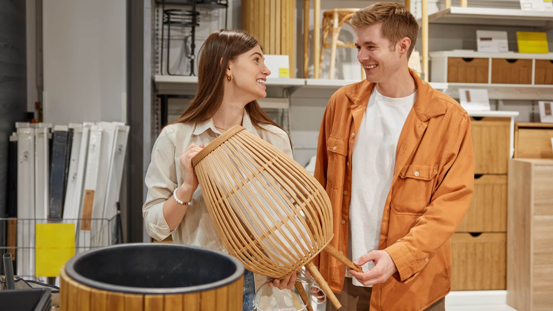 Couple smiling and picking out trendy home decor in a store.