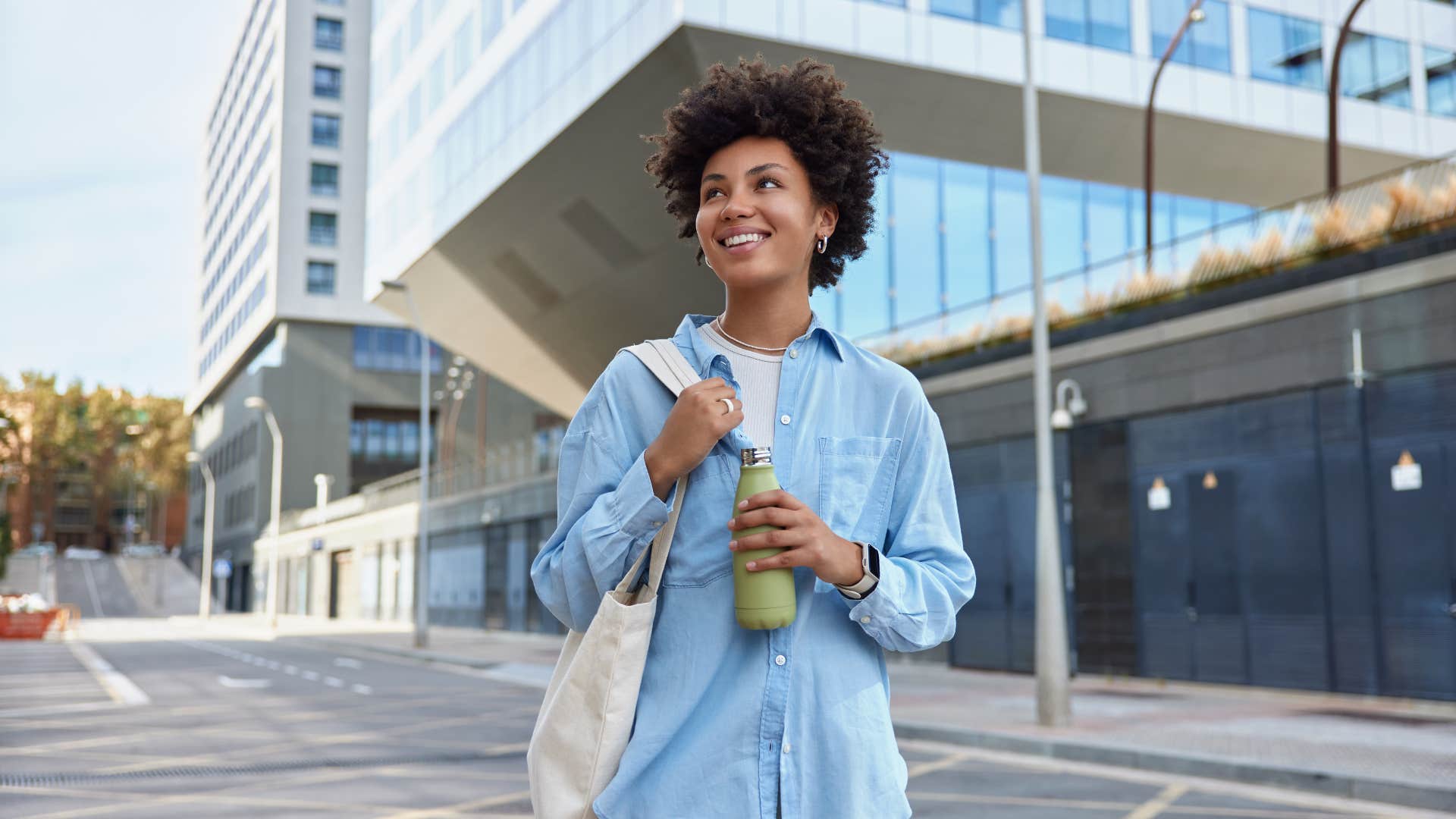 woman carrying reusable water bottle and bag