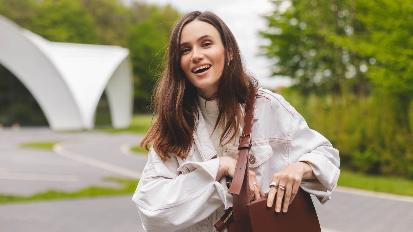 Things Frugal Women Always Keep In Their Bag That Rich Women Don't Even Think About smiling frugal woman holding a purse