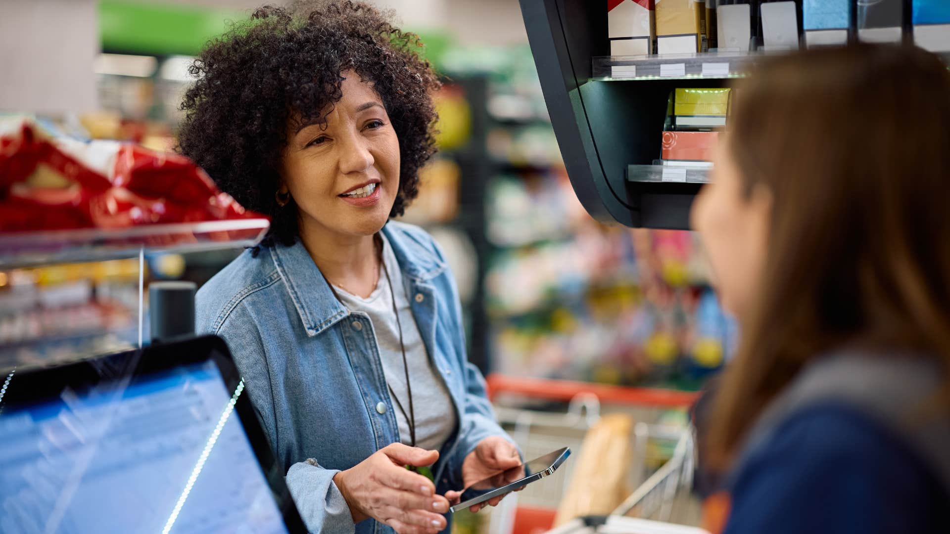 woman using coupons at grocery checkout
