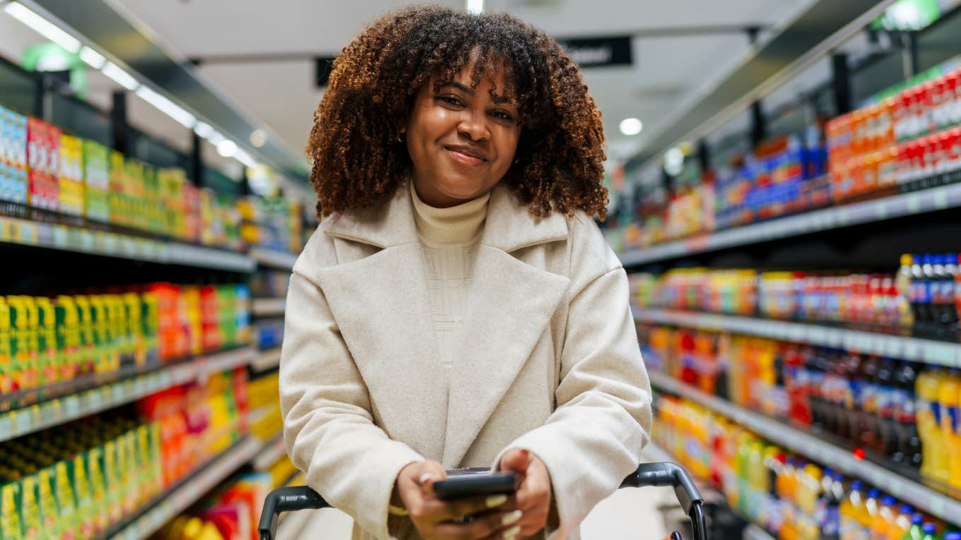 Things Frugal Women Do At The Grocery Store That Save Way More Than You'd Expect frugal woman smiling shopping at the grocery store