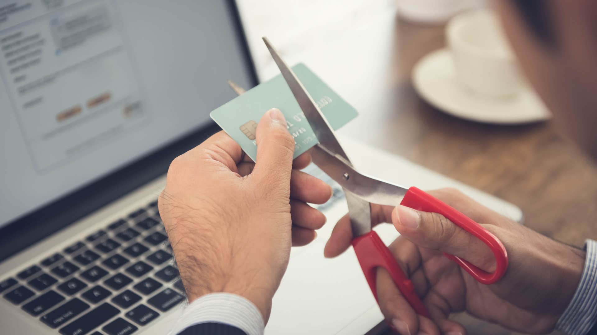 a man cuts up his credit card once and for all after his credit score went down