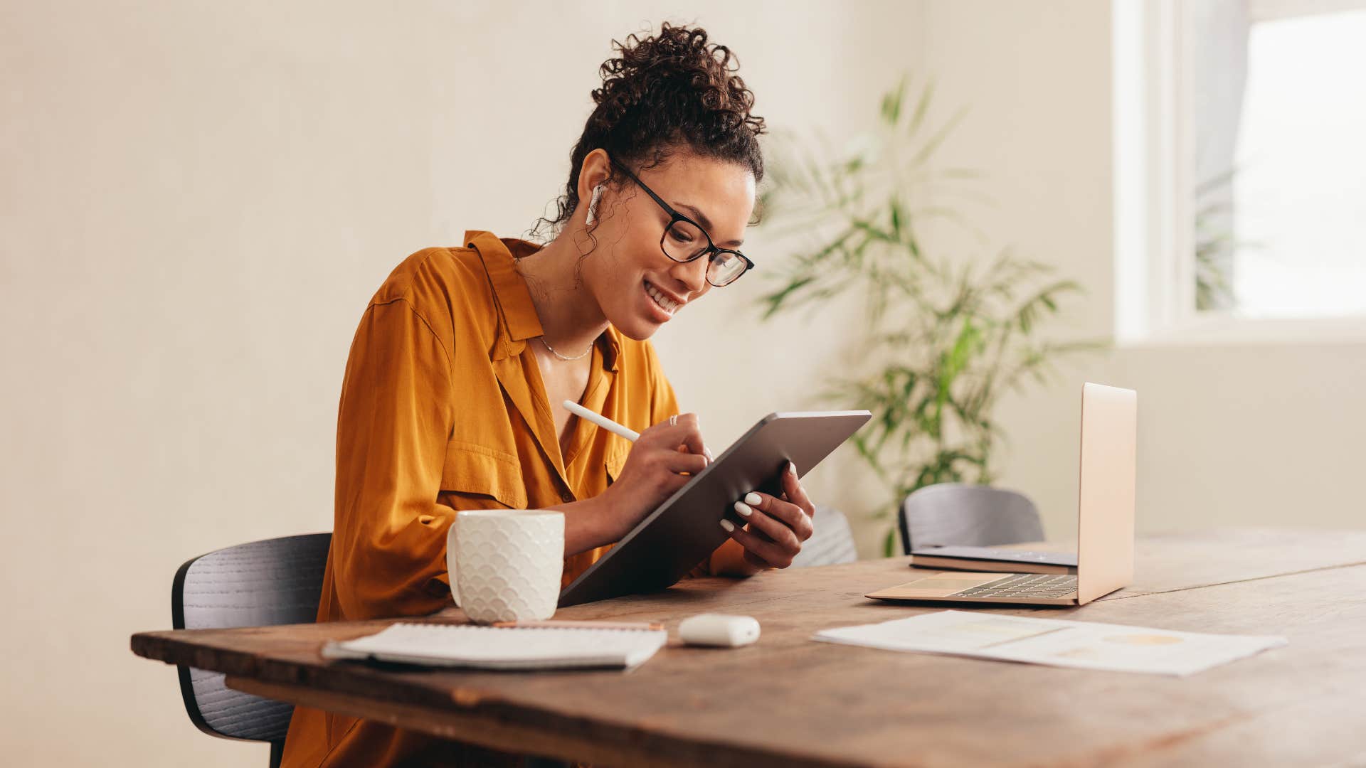 woman with glasses doing digital creativity on laptop