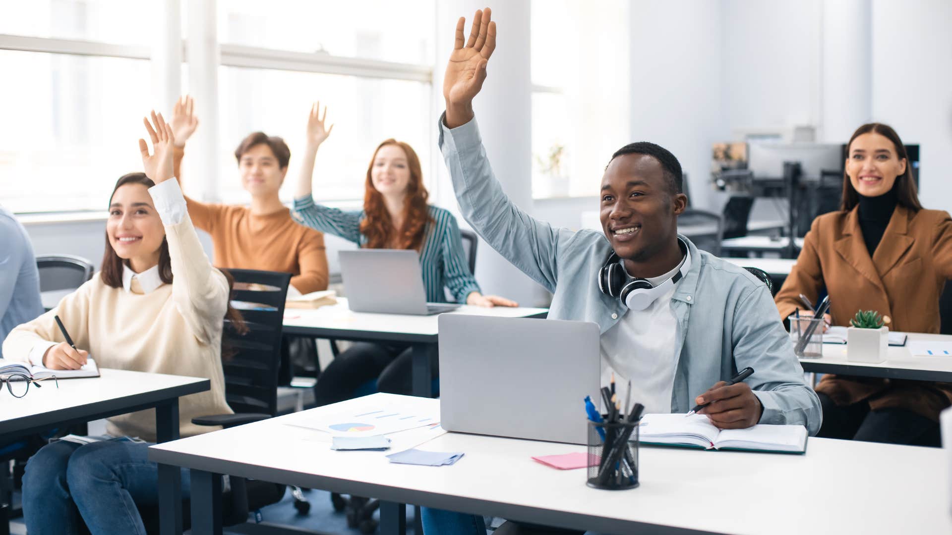man raising hand as he questions religion without fear of judgement