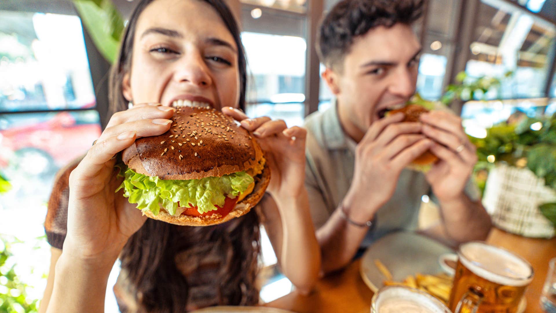 Couple eating junk food at a restaurant.