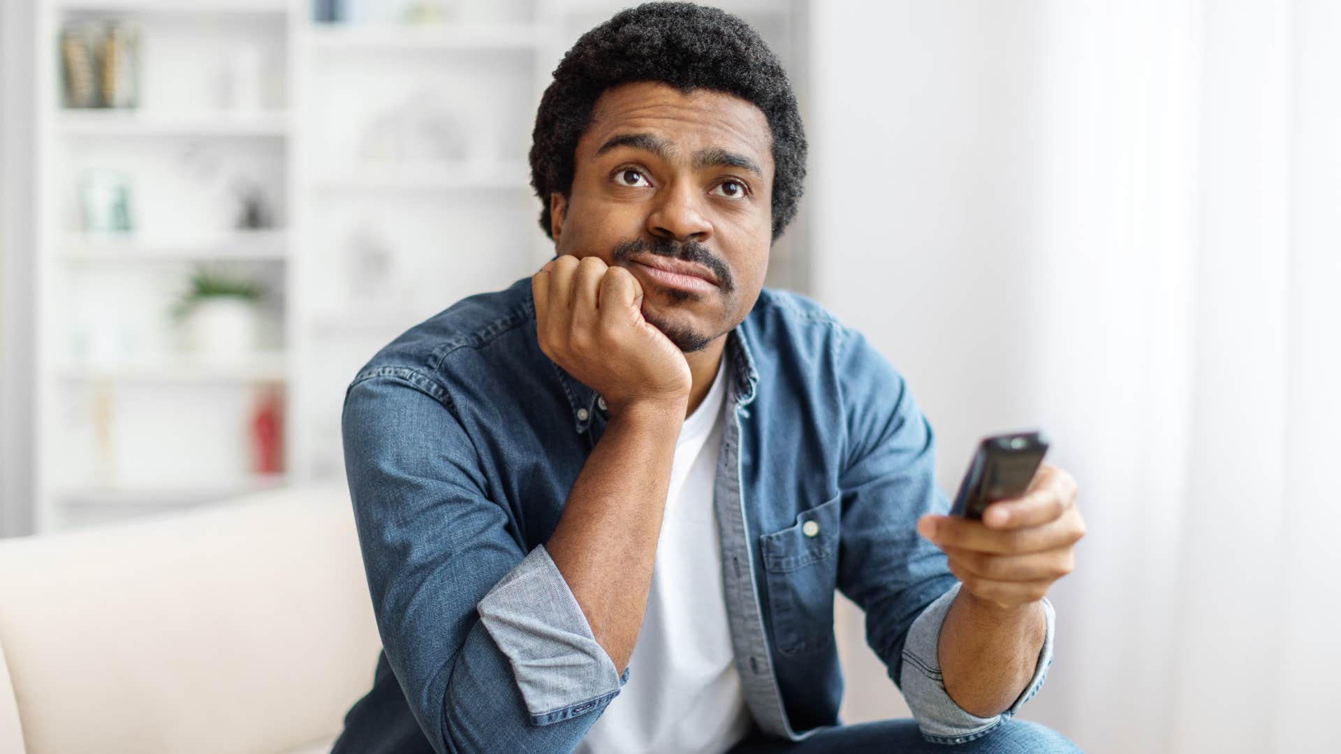 Man consuming mindless entertainment on his TV.