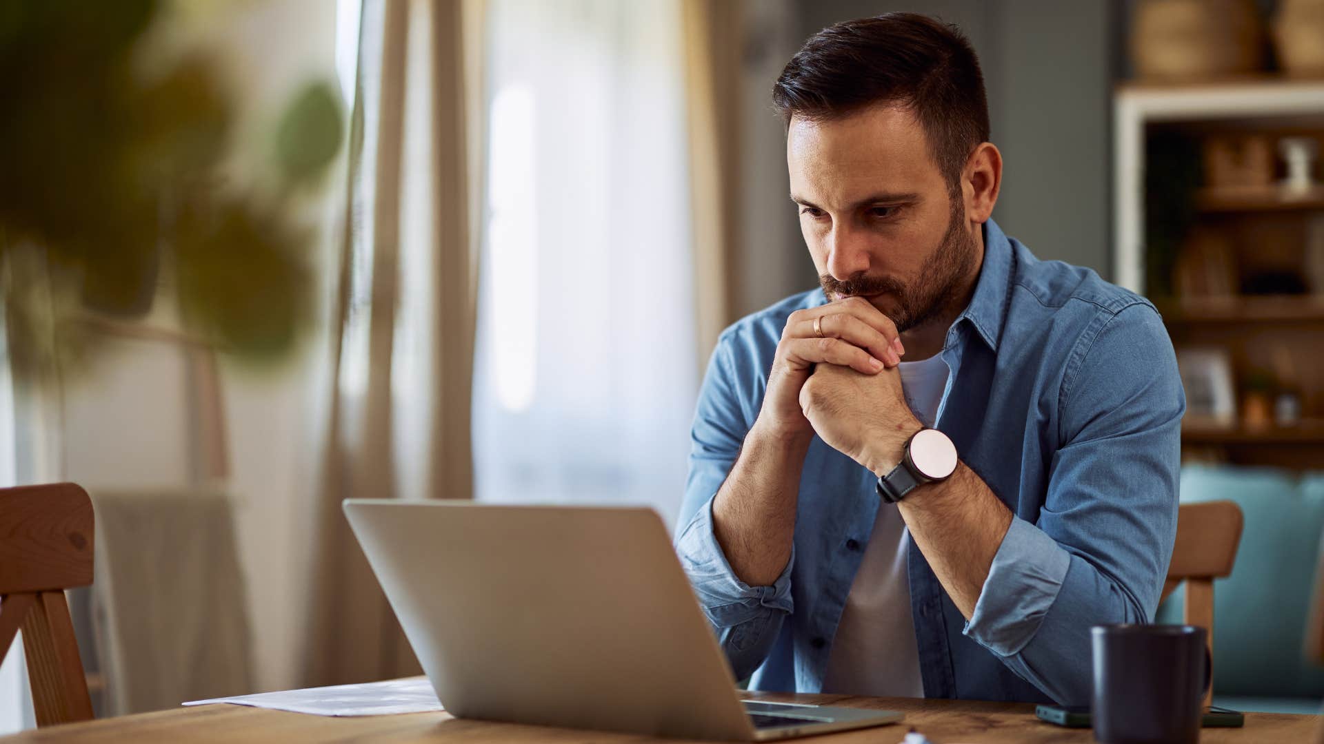 man challenging ideas and questioning himself working at home