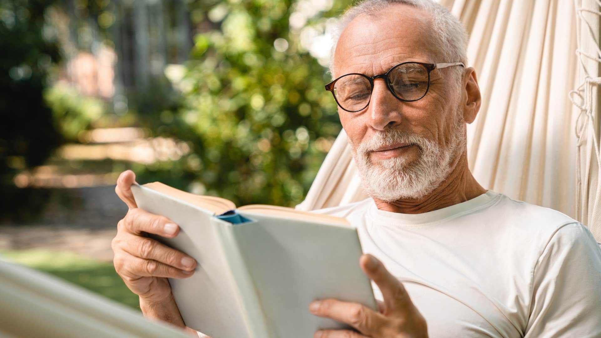 high iq man reading in a hammock
