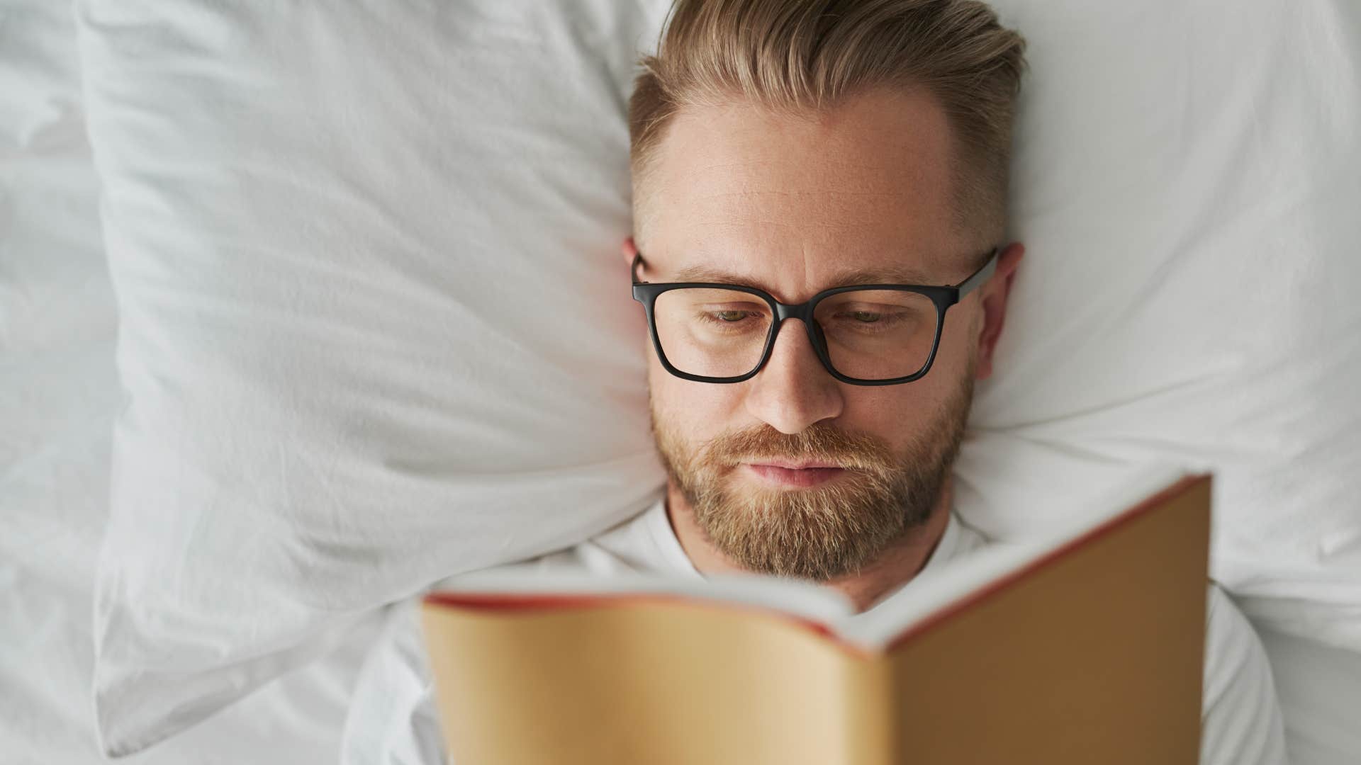 man setting boundaries with screen time reading in bed
