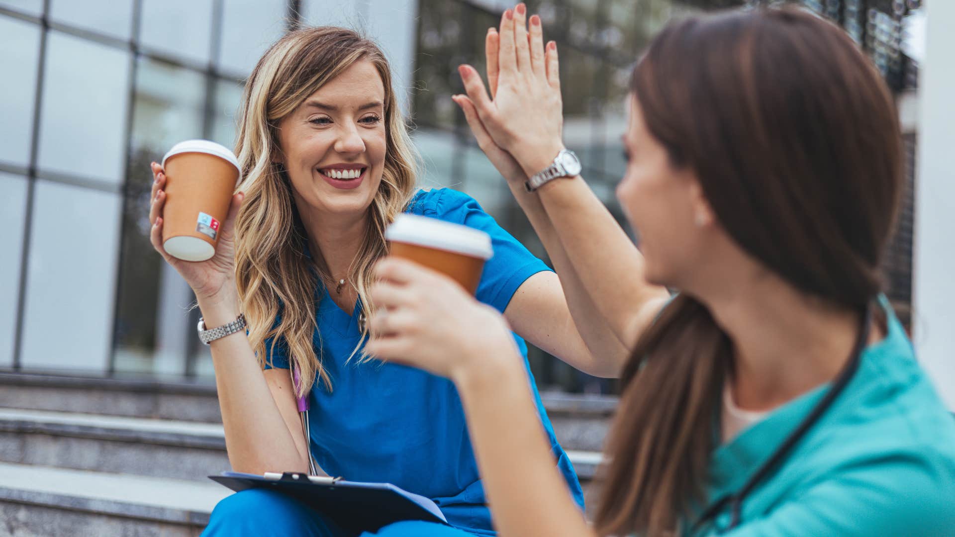 women taking a break at work high-fiving