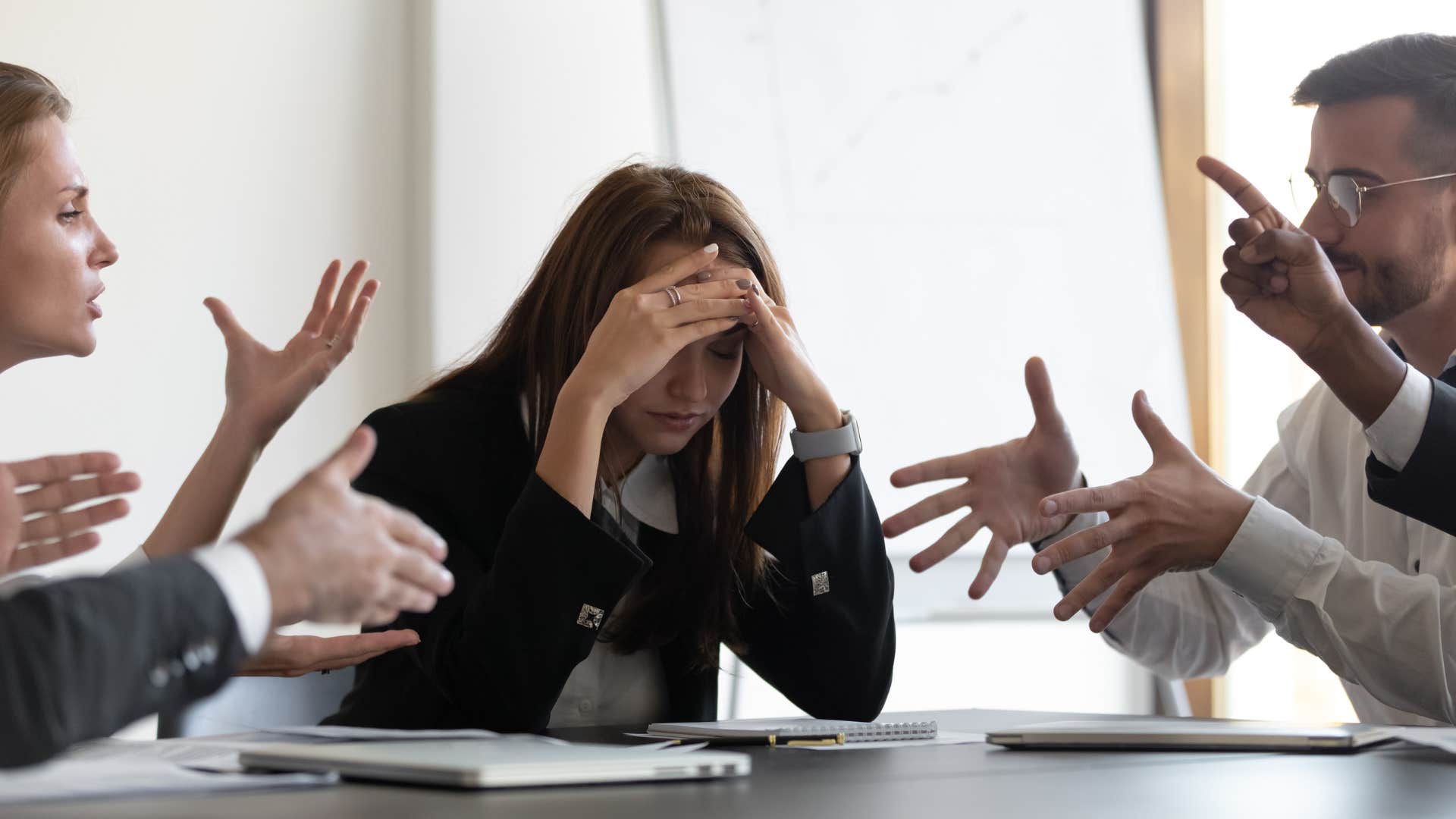 a woman tries to keep her composure as everyone at her job loses their emotional control