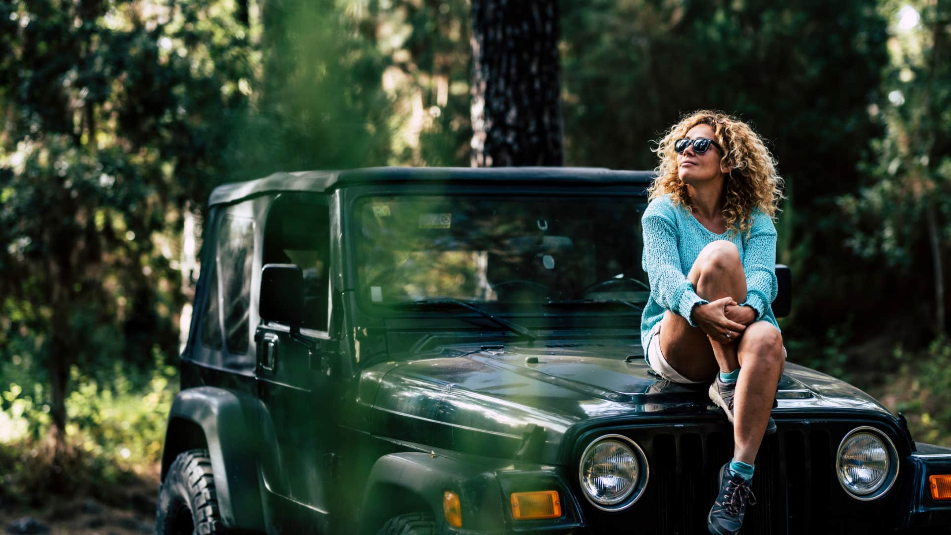independent woman sitting on a car