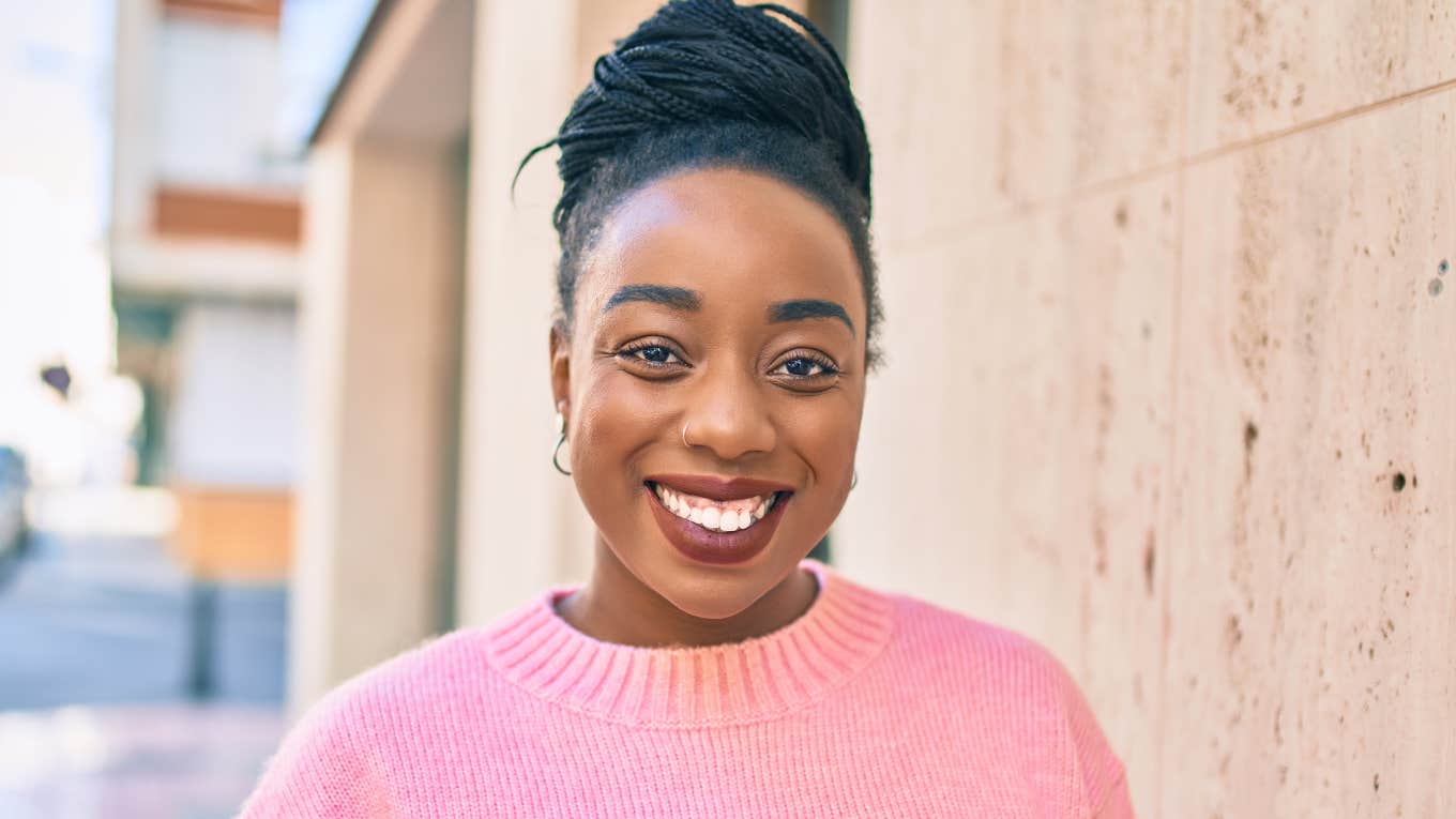 high value woman smiling happily standing outside