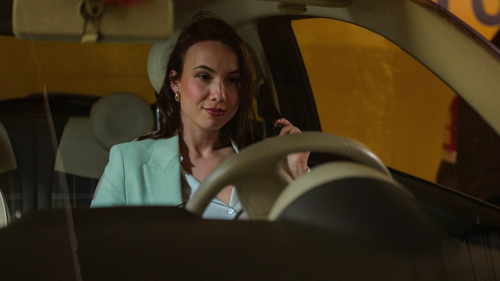 Woman leaving her garage in a fancy car.