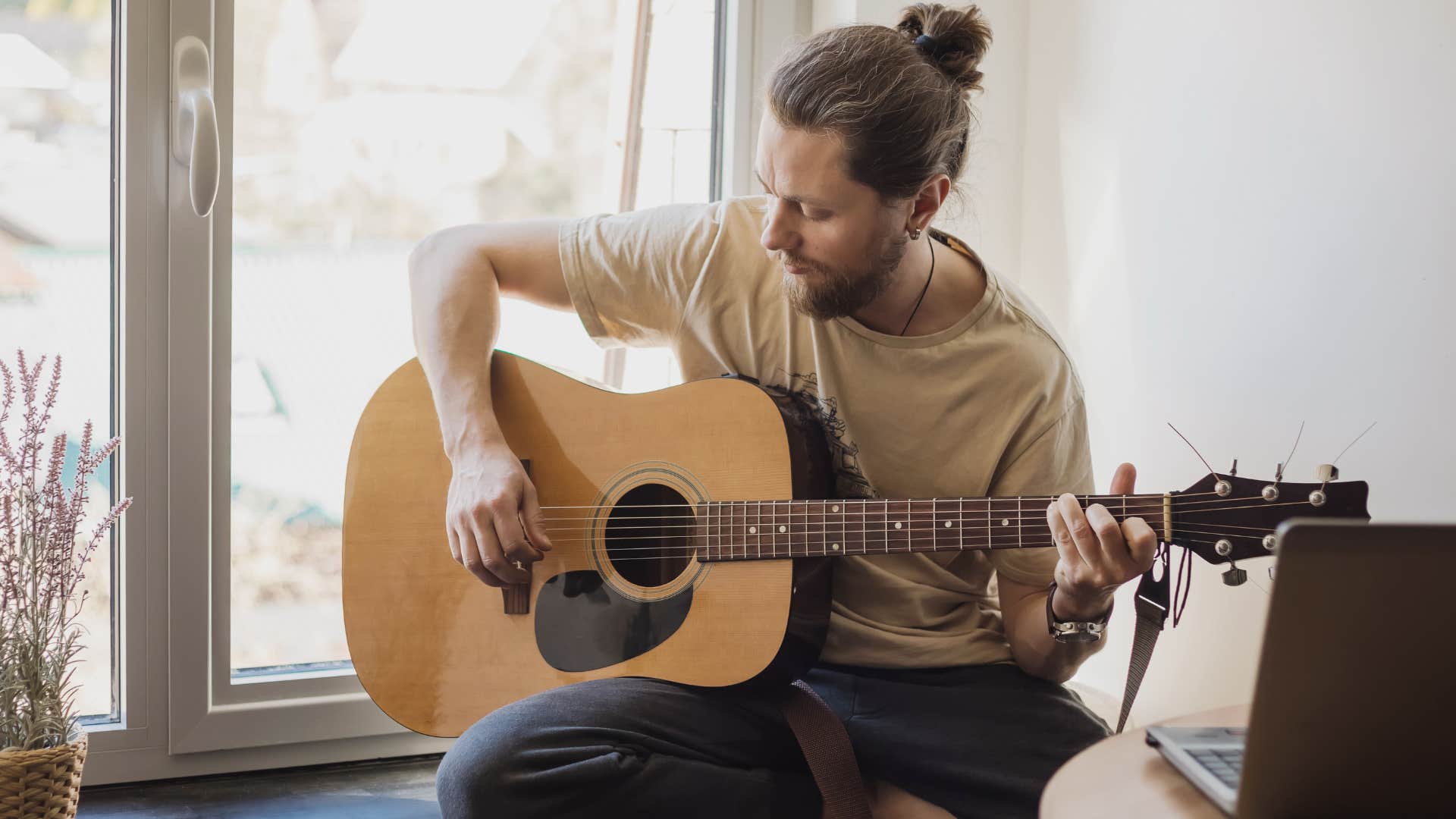 introverted man doing hobbies alone playing guitar