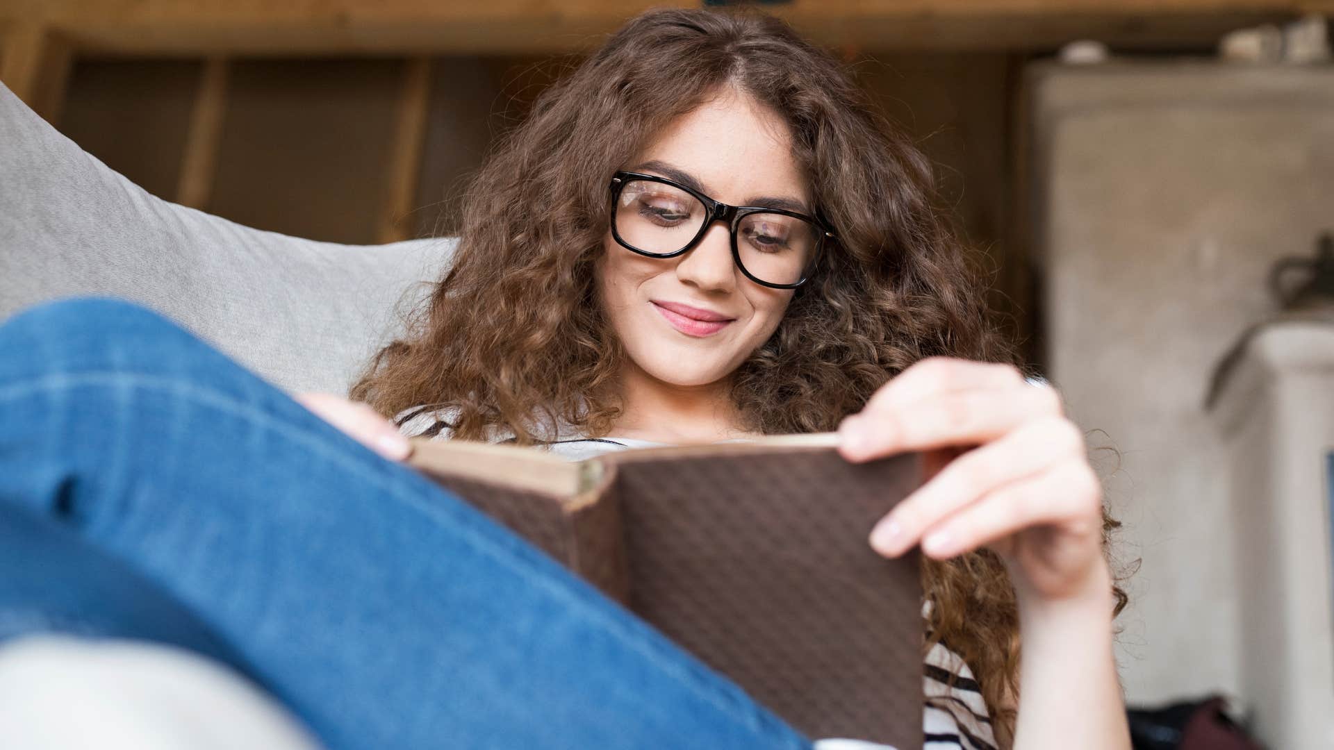 woman putting her phone away and reading to relax