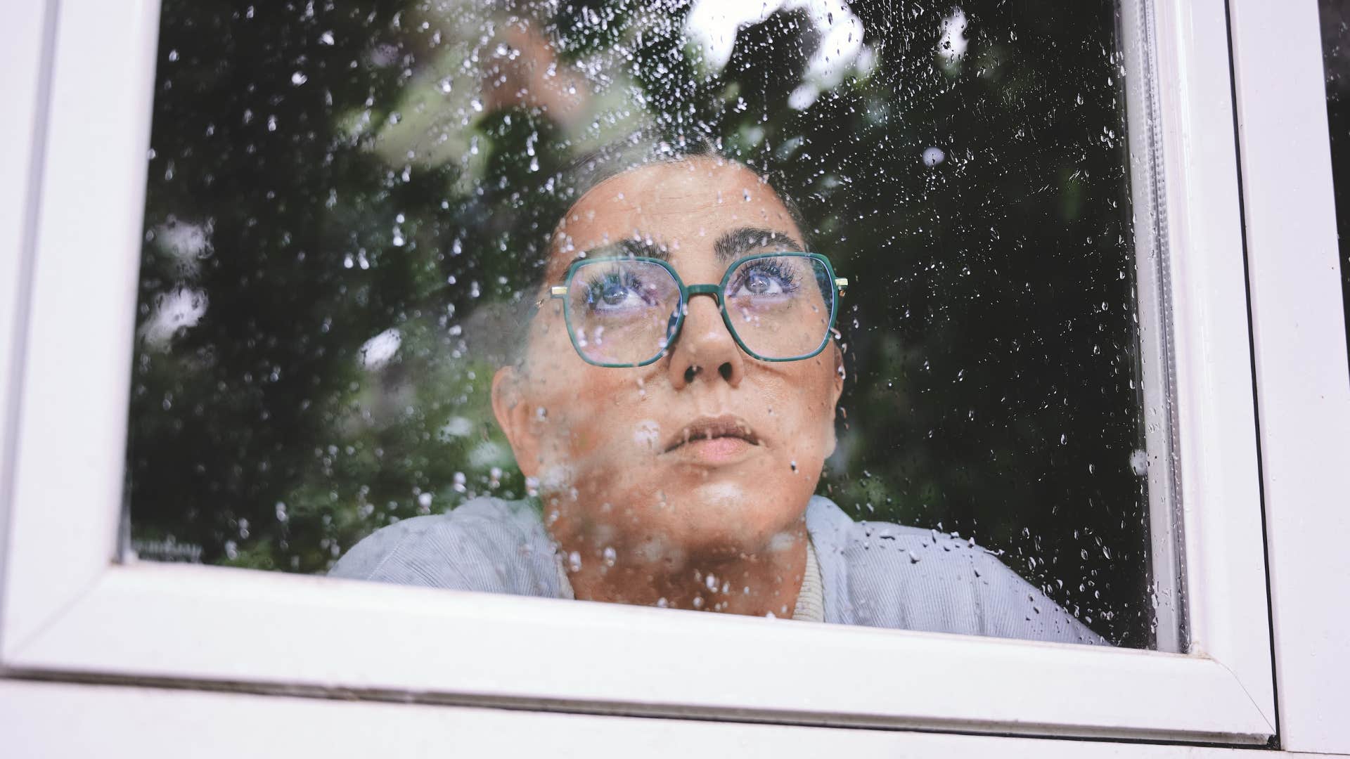 woman looking out the window on a rainy day