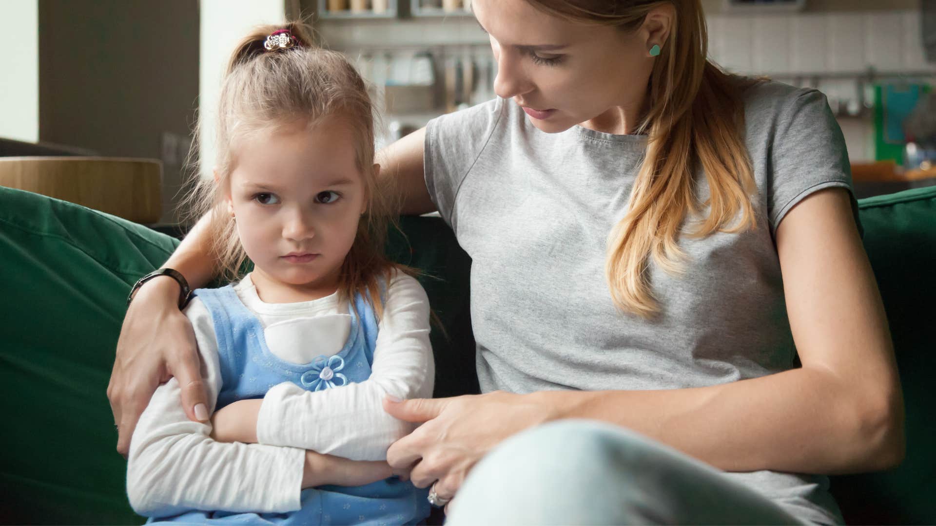 Little girl saying "no" often next to her mother.
