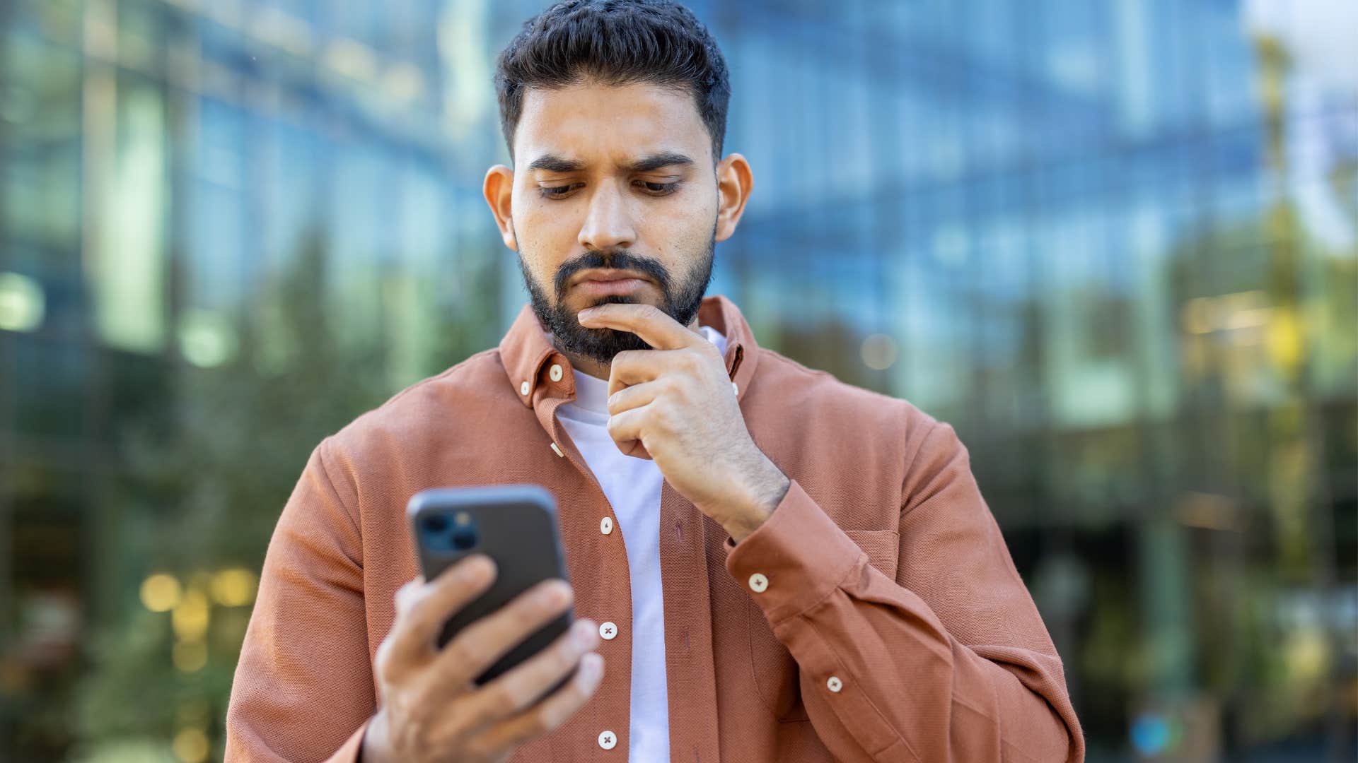 Man looking at conspiracy theories on his phone.
