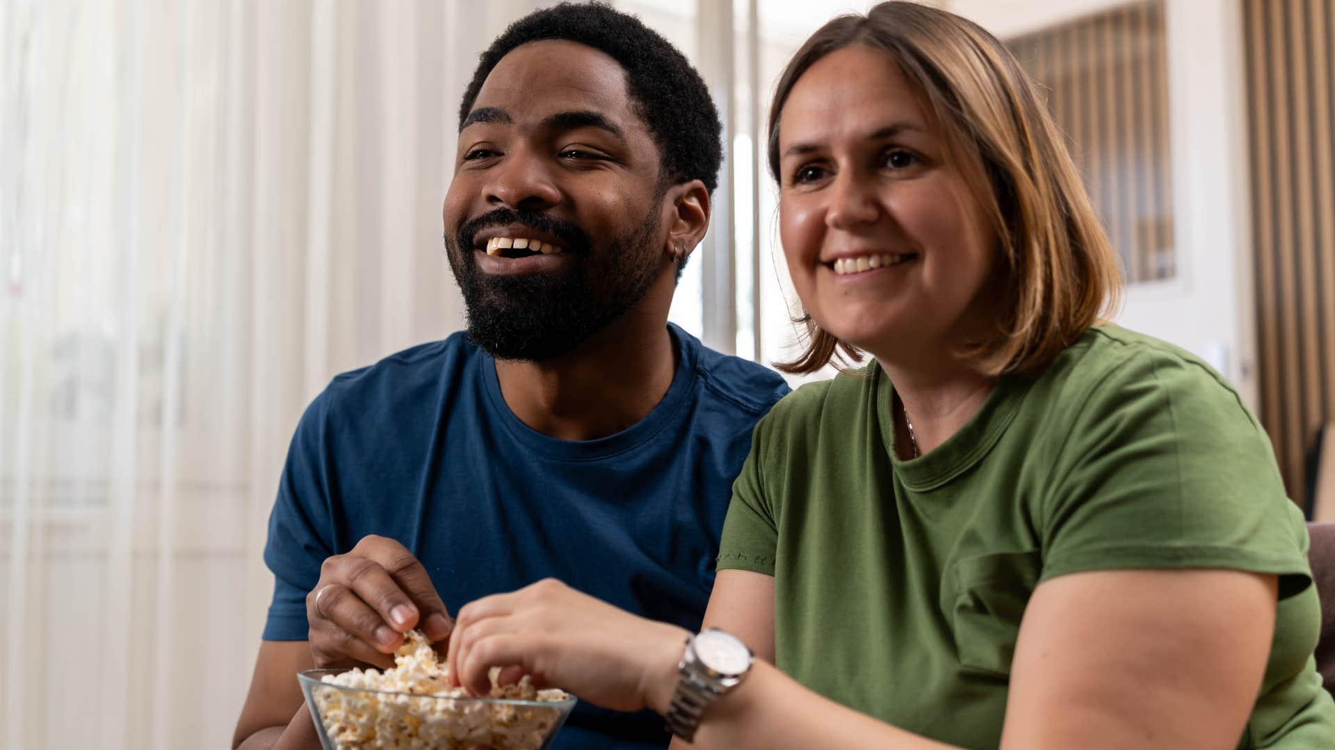 Couple watching reality TV at home.