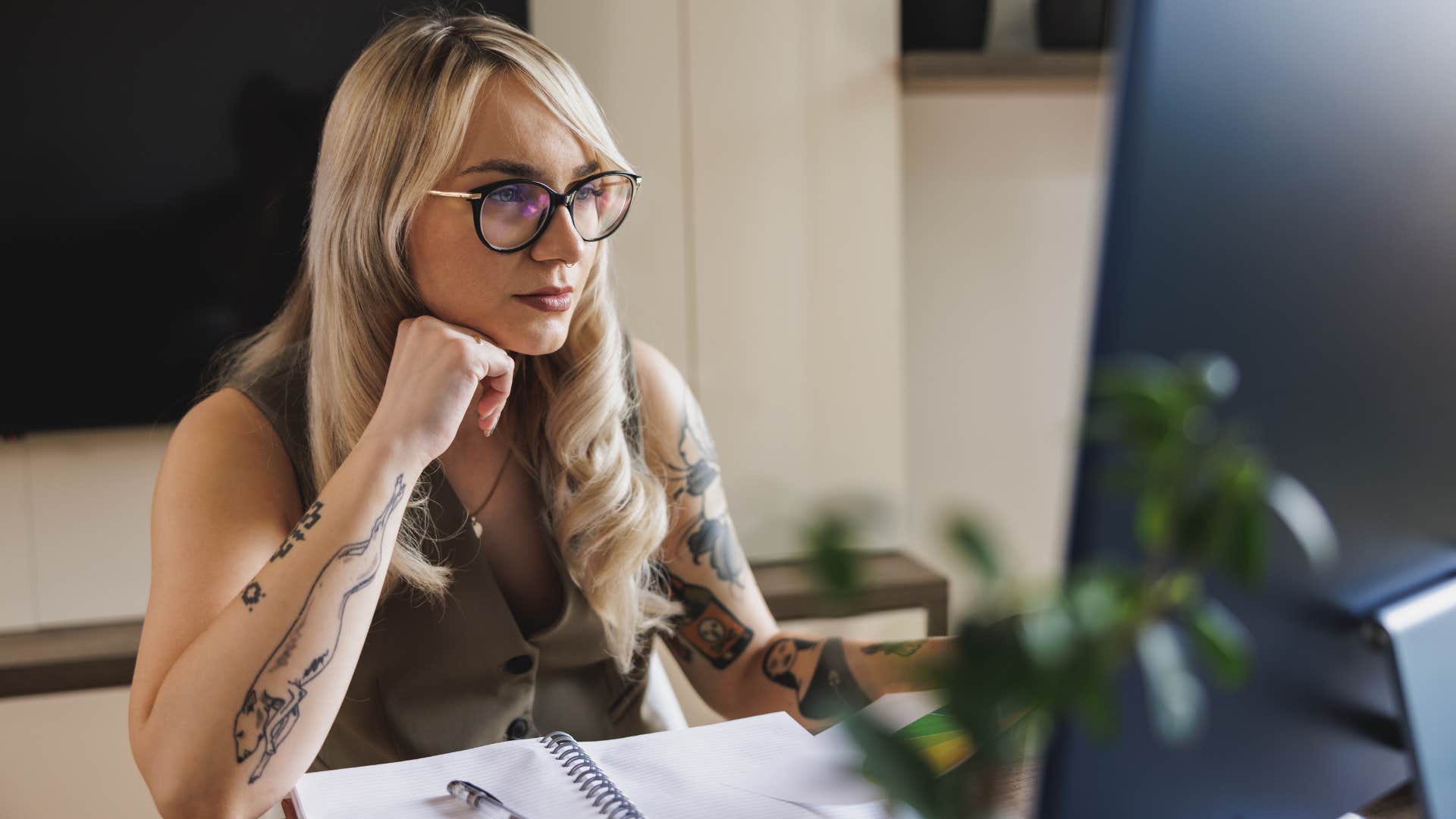 a millennial woman who has tattoos is currently working at a nine to five job