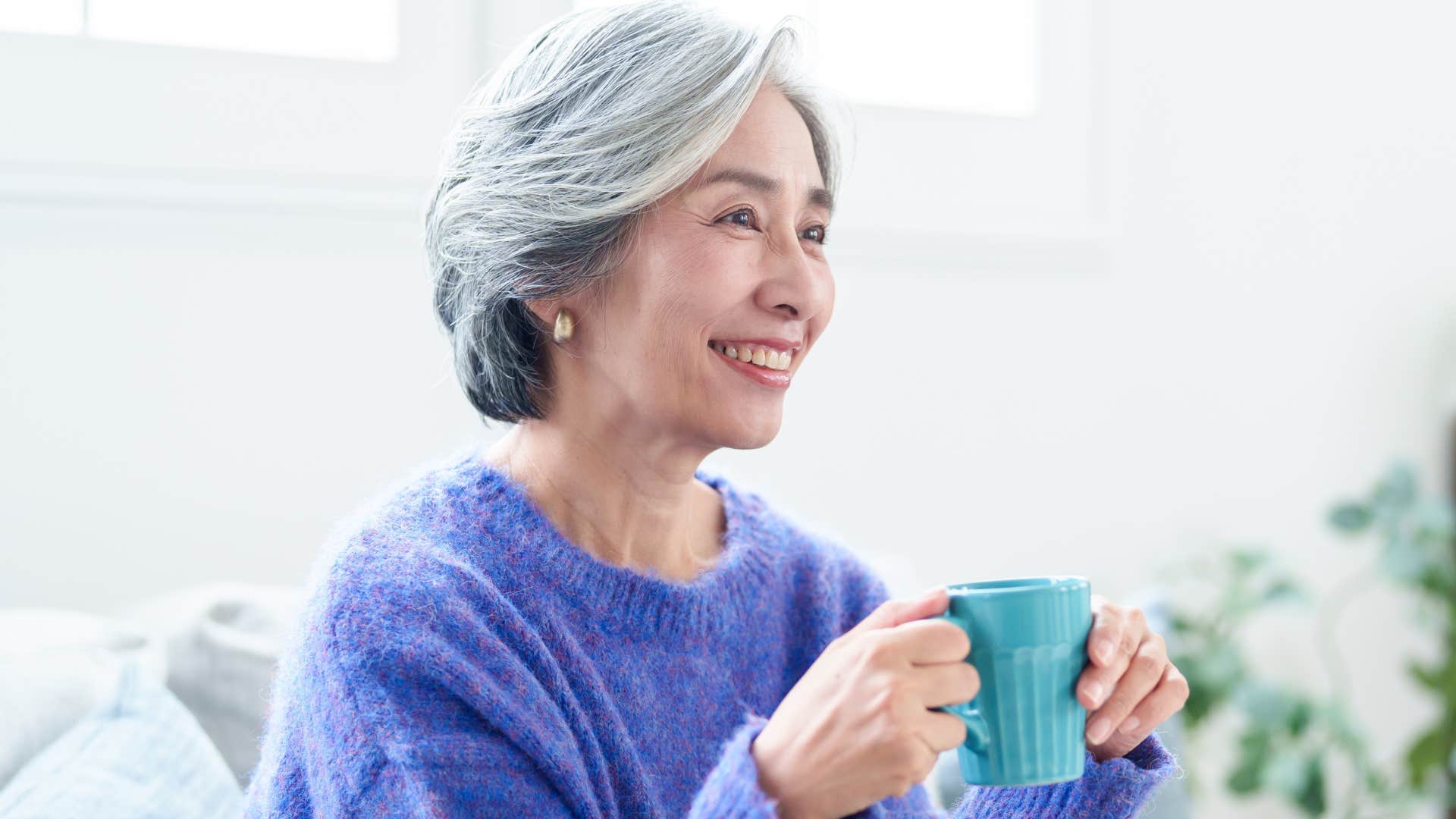 Woman smiling and watching cable tv at home.