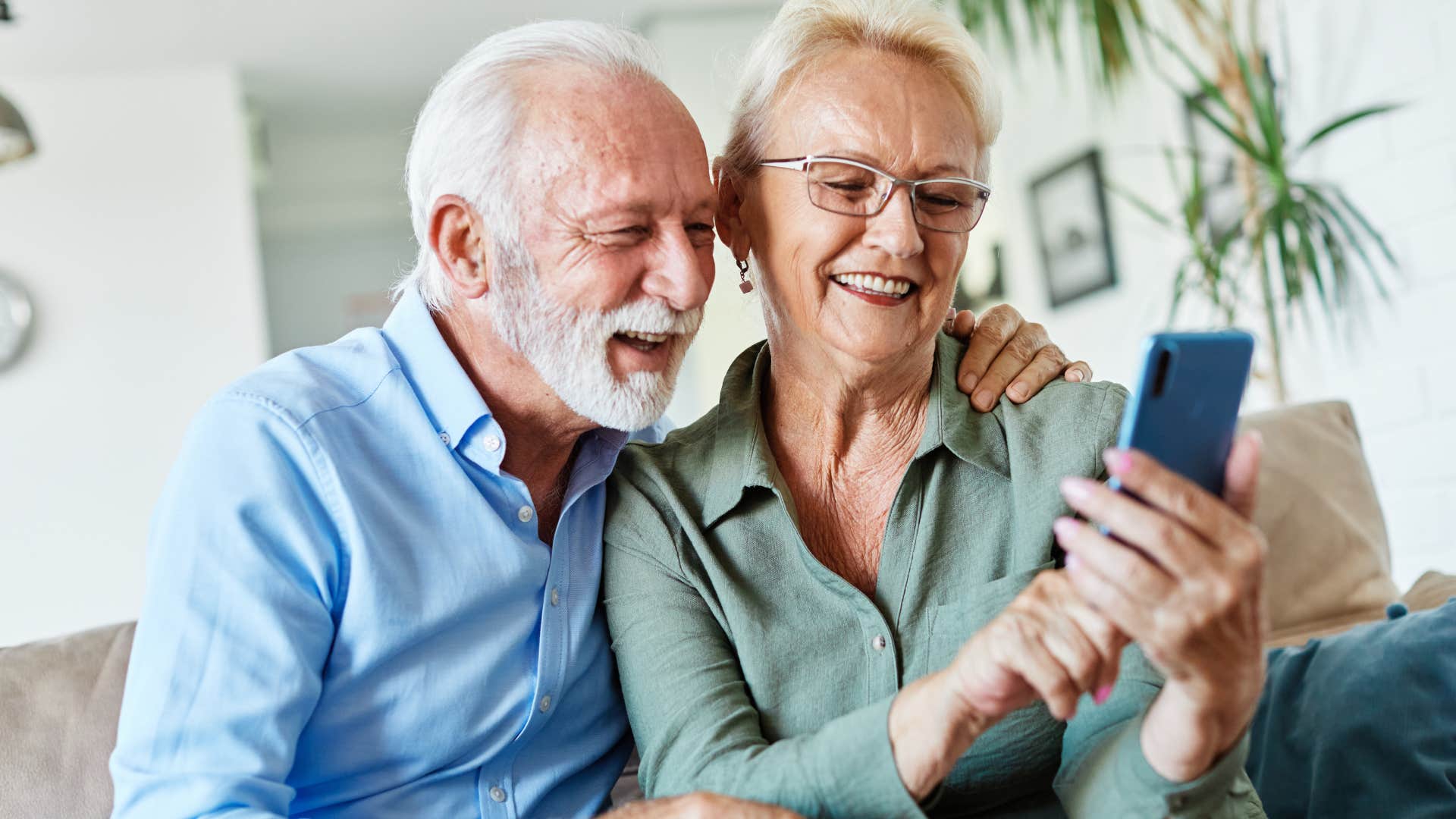 Boomer couple making phone calls at home.