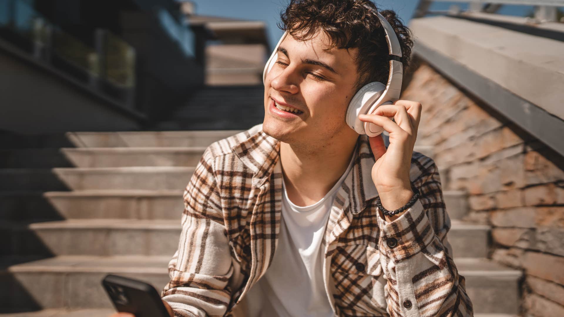 man smiling and listening to pop music with headphones