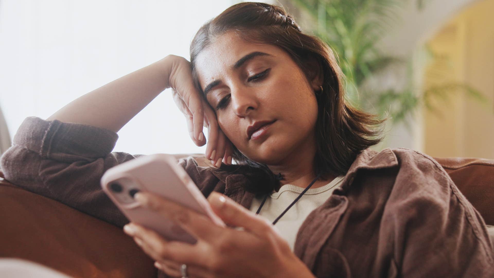 woman scrolling on social media at home