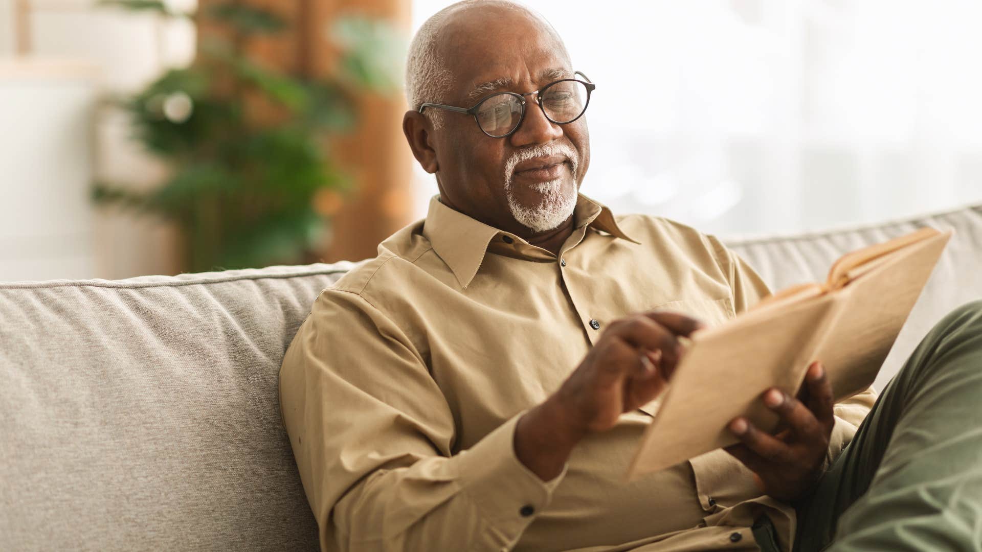 man reading superficial book at home