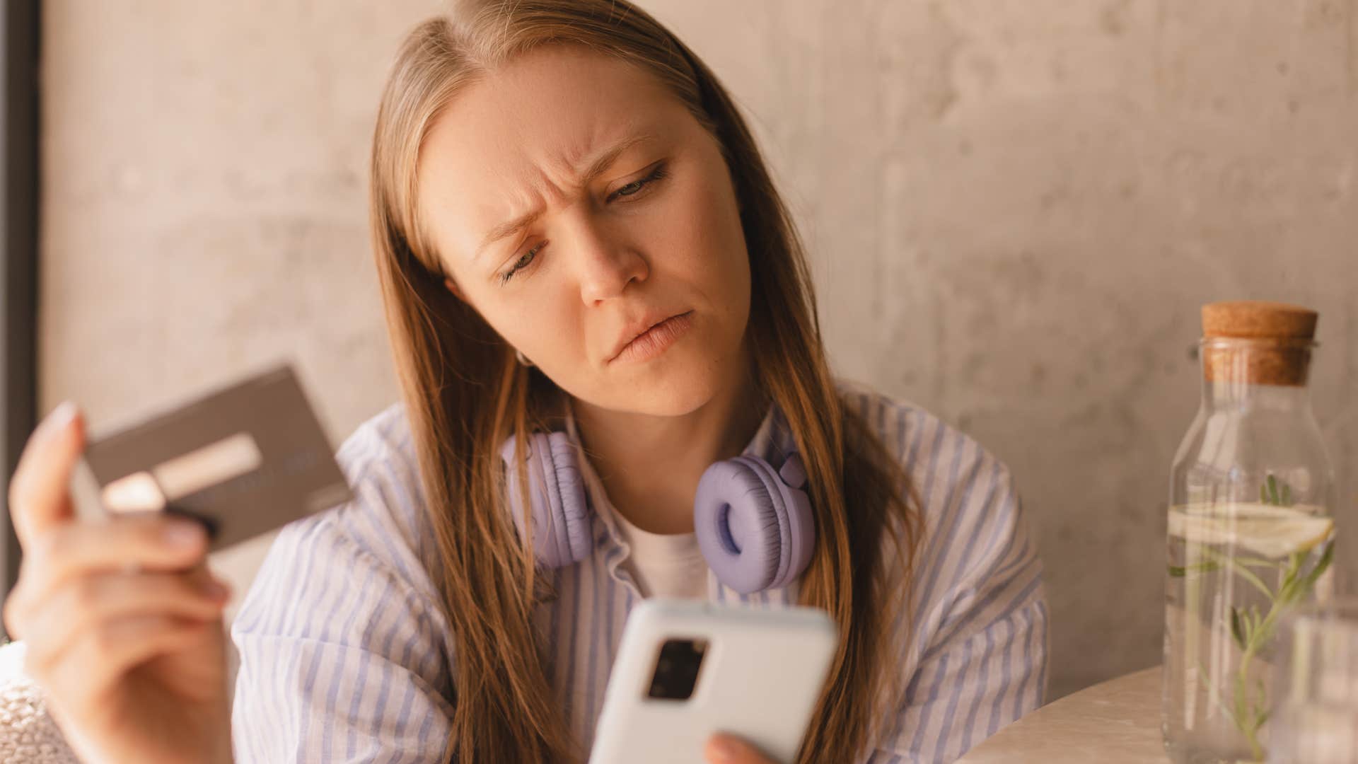working class woman checking her bank account on her phone
