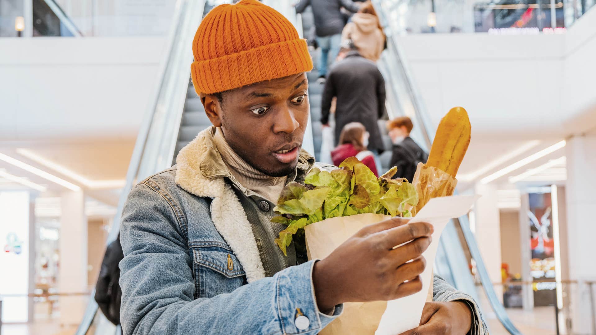 a young man is flabbergasted with the price of his groceries